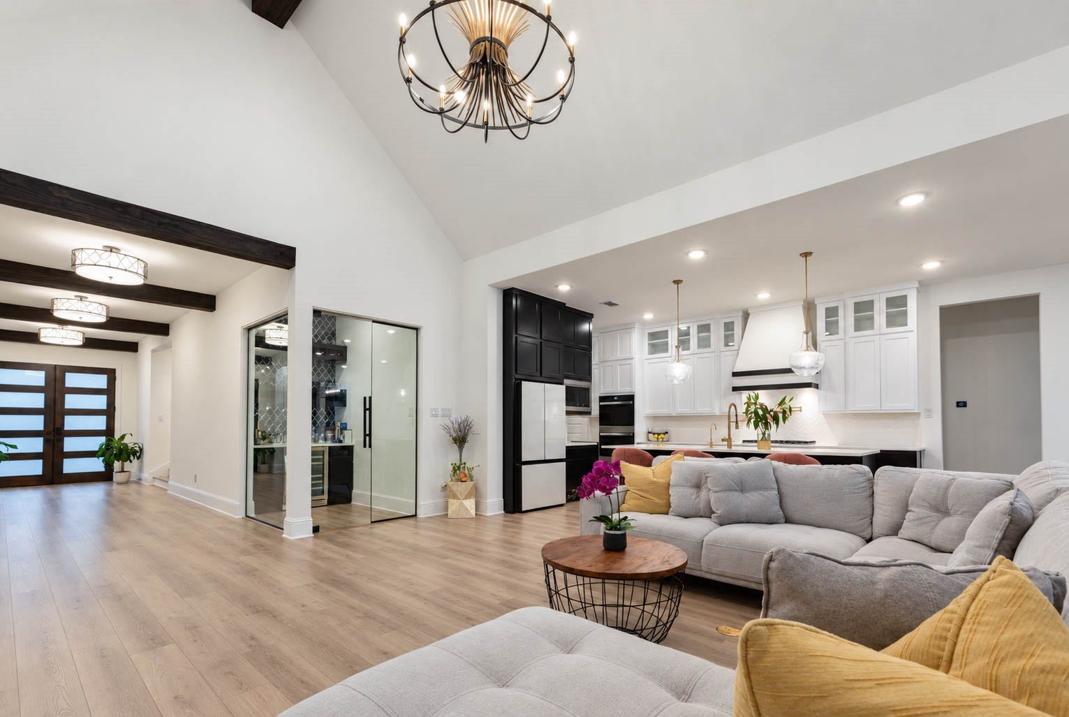 4839 Summer Place Court, Fulshear, TX 77441 Spacious open-concept living area with vaulted ceilings, featuring a modern kitchen with sleek cabinetry and a large island, complemented by a stunning wine bar to add that wow factor.