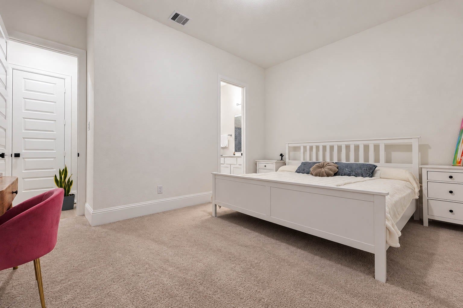 4839 Summer Place Court, Fulshear, TX 77441 Spacious and inviting bedroom featuring plush carpeting, a stylish white bed frame, and a convenient en-suite bathroom, perfect for relaxation and comfort.