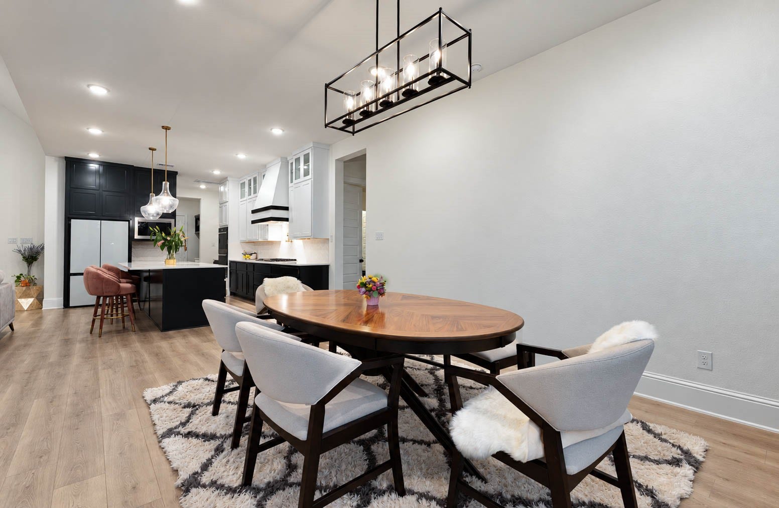 4839 Summer Place Court, Fulshear, TX 77441 Bright and spacious open-concept dining area with modern fixtures, flowing into a chic kitchen with a large island and contemporary lighting.