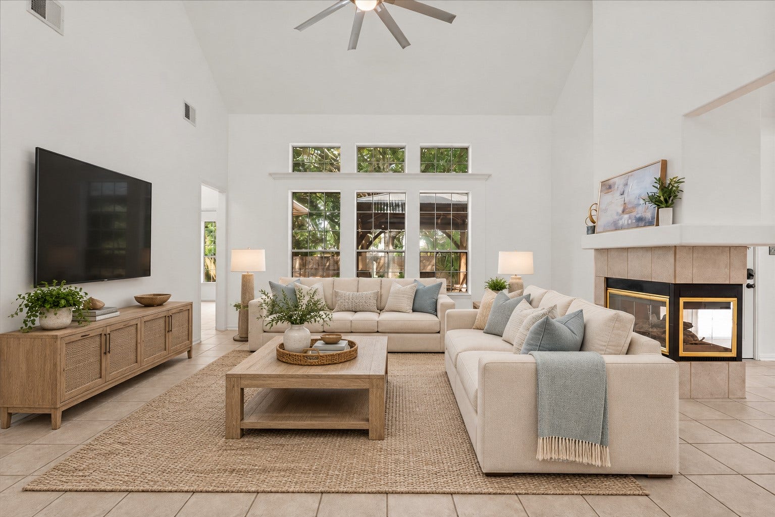 311 Lake Front Drive, League City, TX 77573 Oversized family room with vaulted ceilings, tons of natural light, and a three-sided fireplace shared with the breakfast area. Virtually staged.