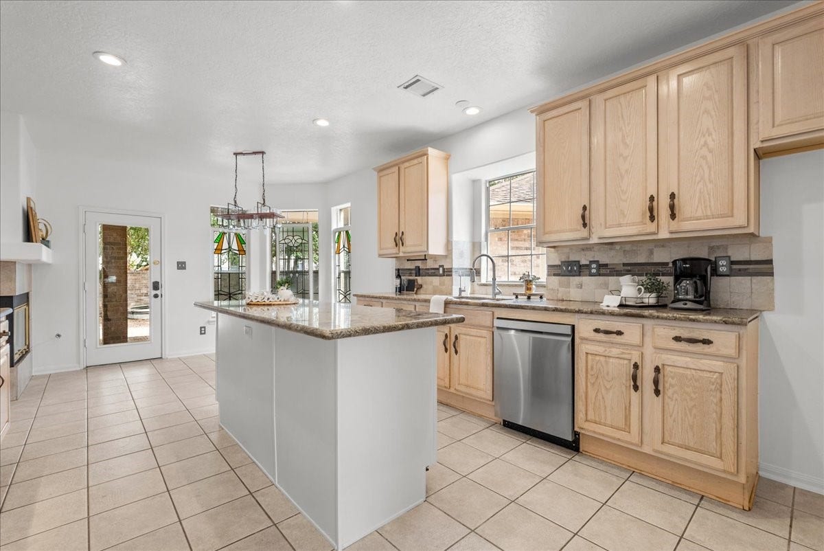 311 Lake Front Drive, League City, TX 77573 Imagine entertaining in this beautiful kitchen featuring granite countertops, stainless steel appliances, and a center island with extra storage.