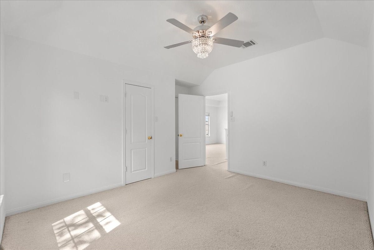 311 Lake Front Drive, League City, TX 77573 This bedroom has a vaulted ceiling and beautiful crystal light fixture/fan combo and an attached en-suite bathroom.