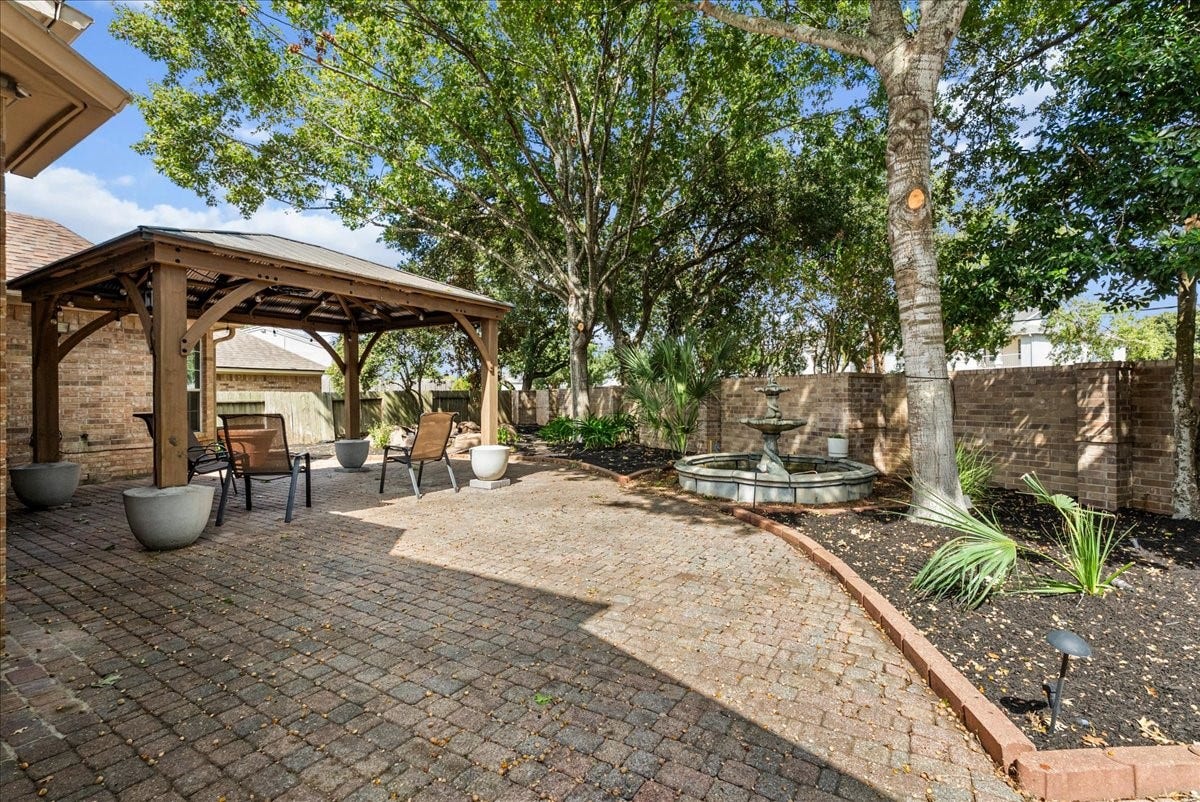 311 Lake Front Drive, League City, TX 77573 Paver patio with an oversized pergola and tiered fountain, perfect for relaxing or entertaining outside.