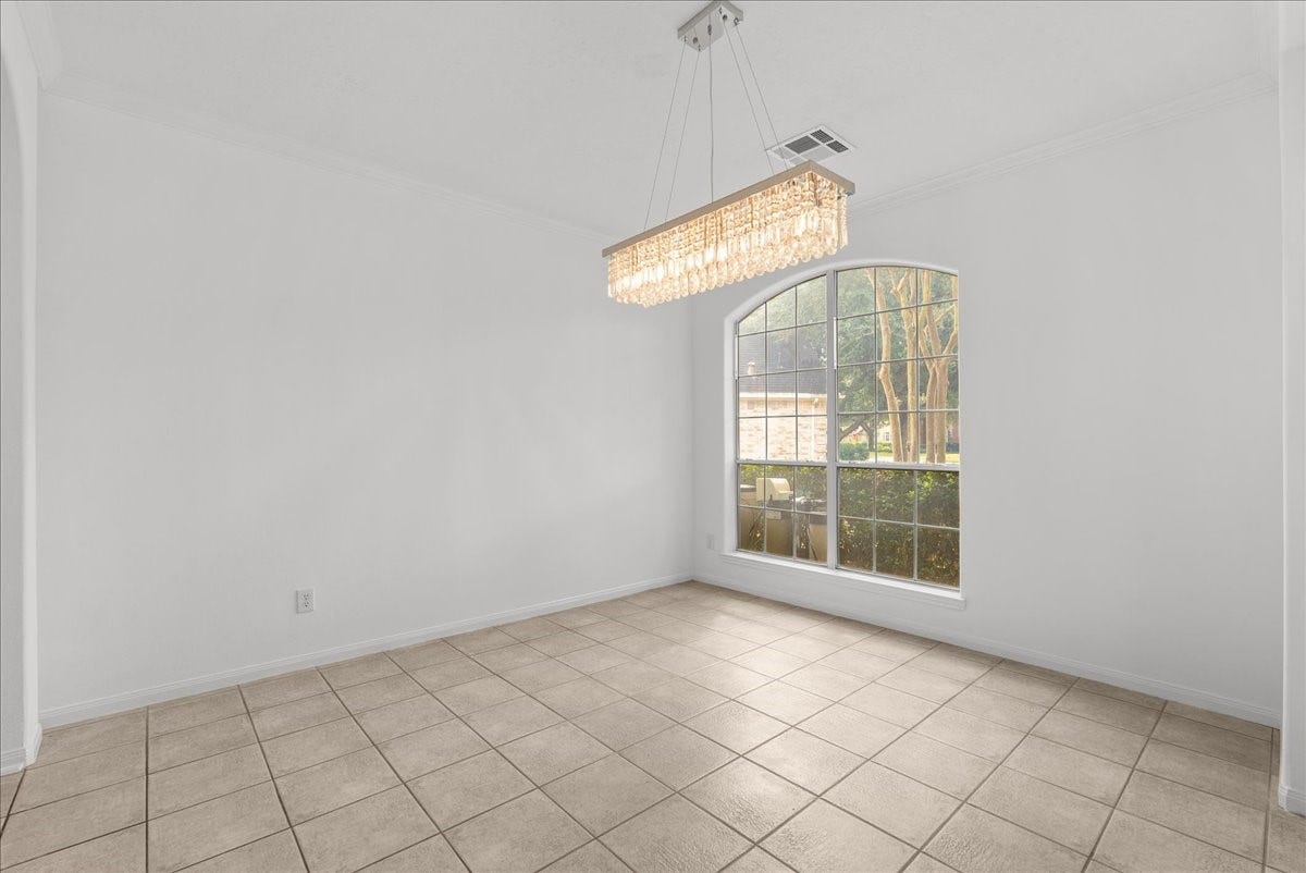 311 Lake Front Drive, League City, TX 77573 Spacious Formal dining room with a crystal chandelier and a tall arched window.