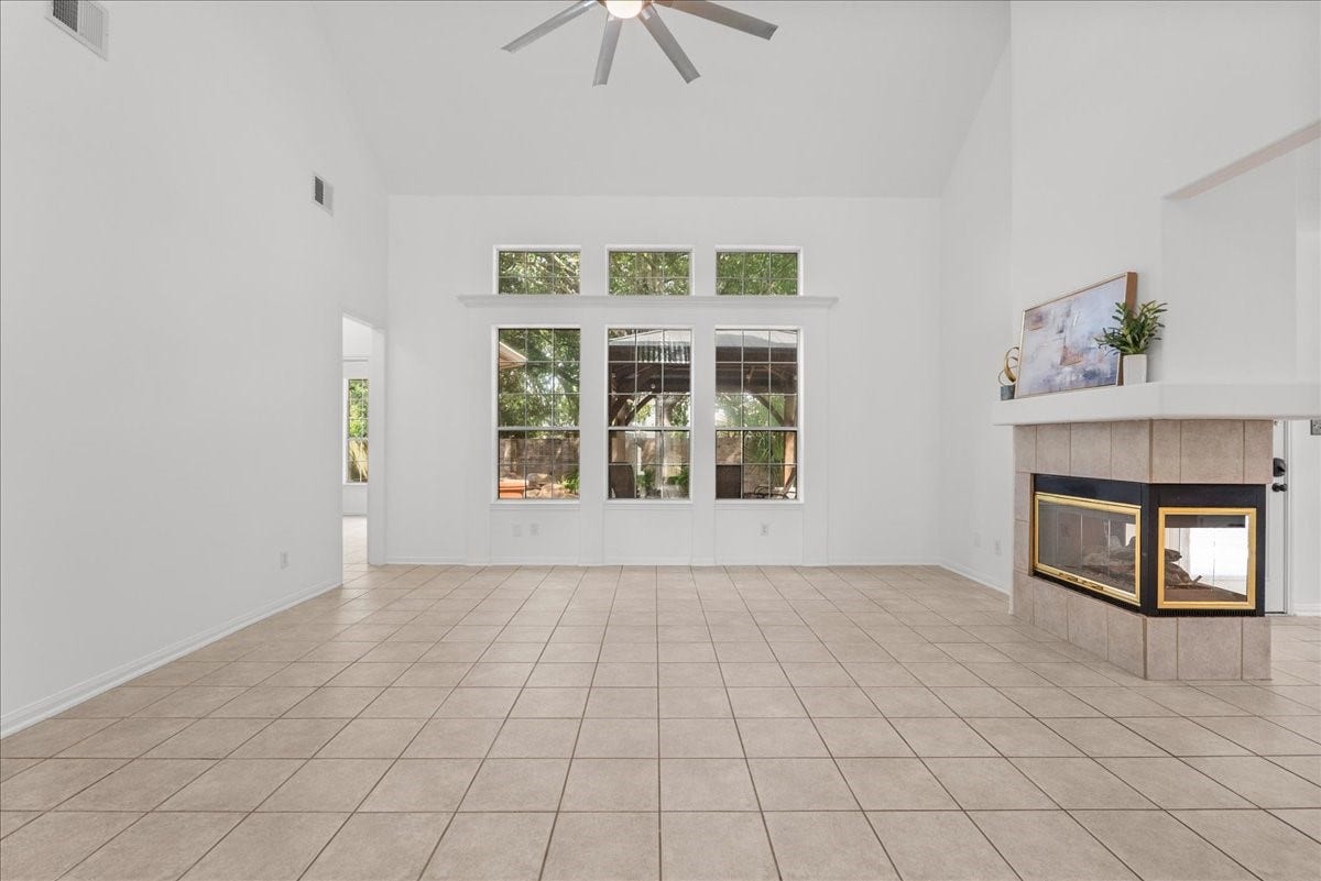 311 Lake Front Drive, League City, TX 77573 Oversized family room with vaulted ceilings, tons of natural light, and a three-sided fireplace shared with the breakfast area.