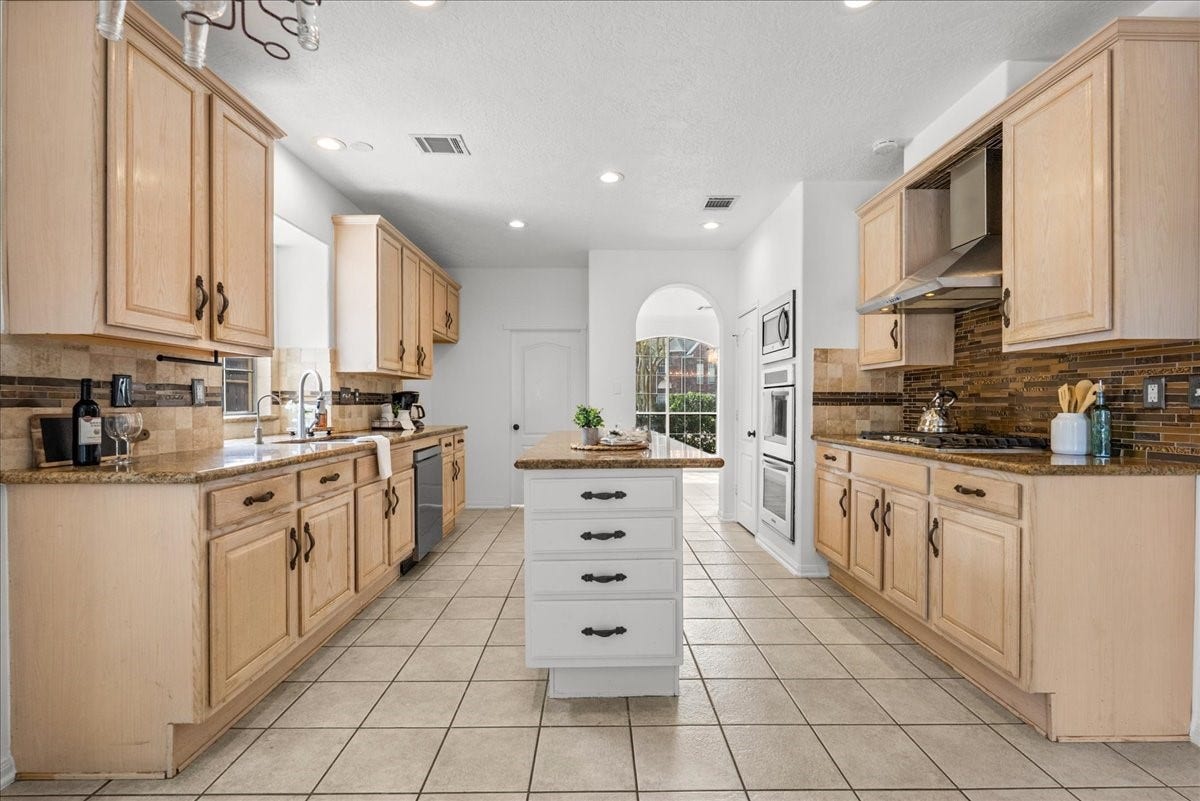 311 Lake Front Drive, League City, TX 77573 Imagine entertaining in this beautiful kitchen featuring granite countertops, stainless steel appliances, and a center island with extra storage.
