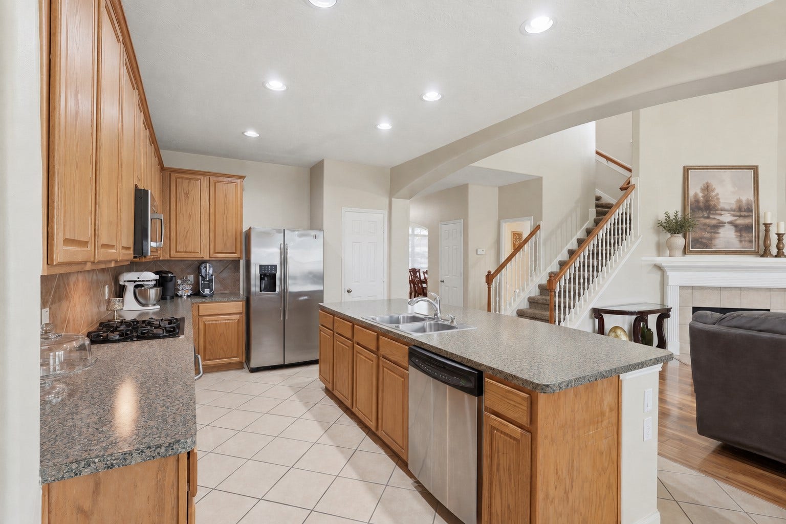 11404 Summit Bay Drive, Pearland, TX 77584 Spacious kitchen featuring abundant cabinetry and counter space, built-in stainless steel appliances, a tile backsplash, a large center island, and bright recessed lighting. The open layout facilitates both meal preparation