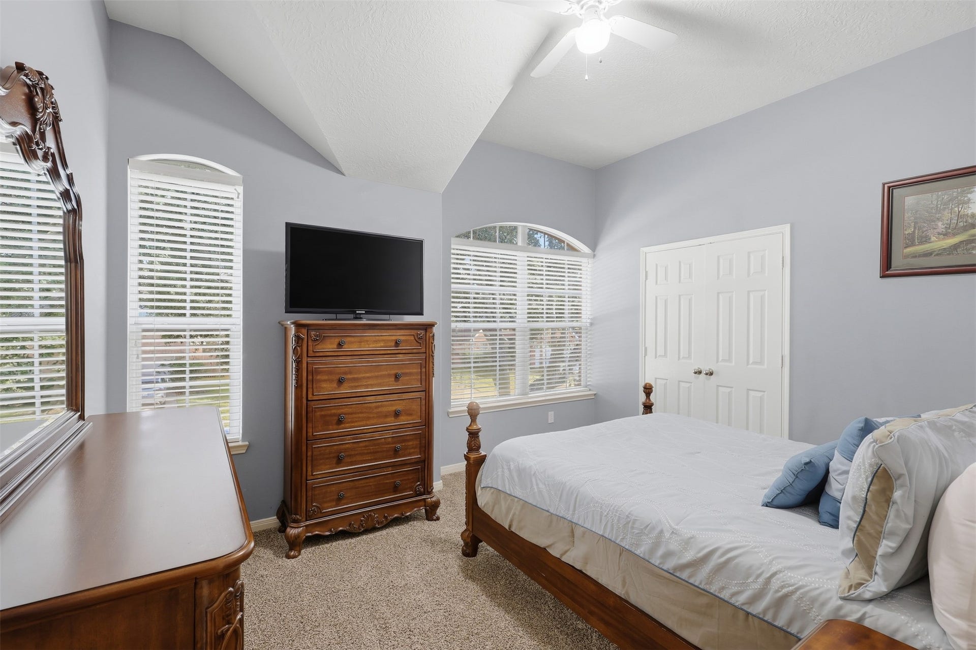 11404 Summit Bay Drive, Pearland, TX 77584 Spacious secondary bedroom with plush carpeting, multiple windows adorned with plantation-style blinds, a ceiling fan, and ample floor space. The bright, inviting layout comfortably accommodates a bedroom set, dresser, and personal touches. French doors open to a large, well-designed walk-in closet.