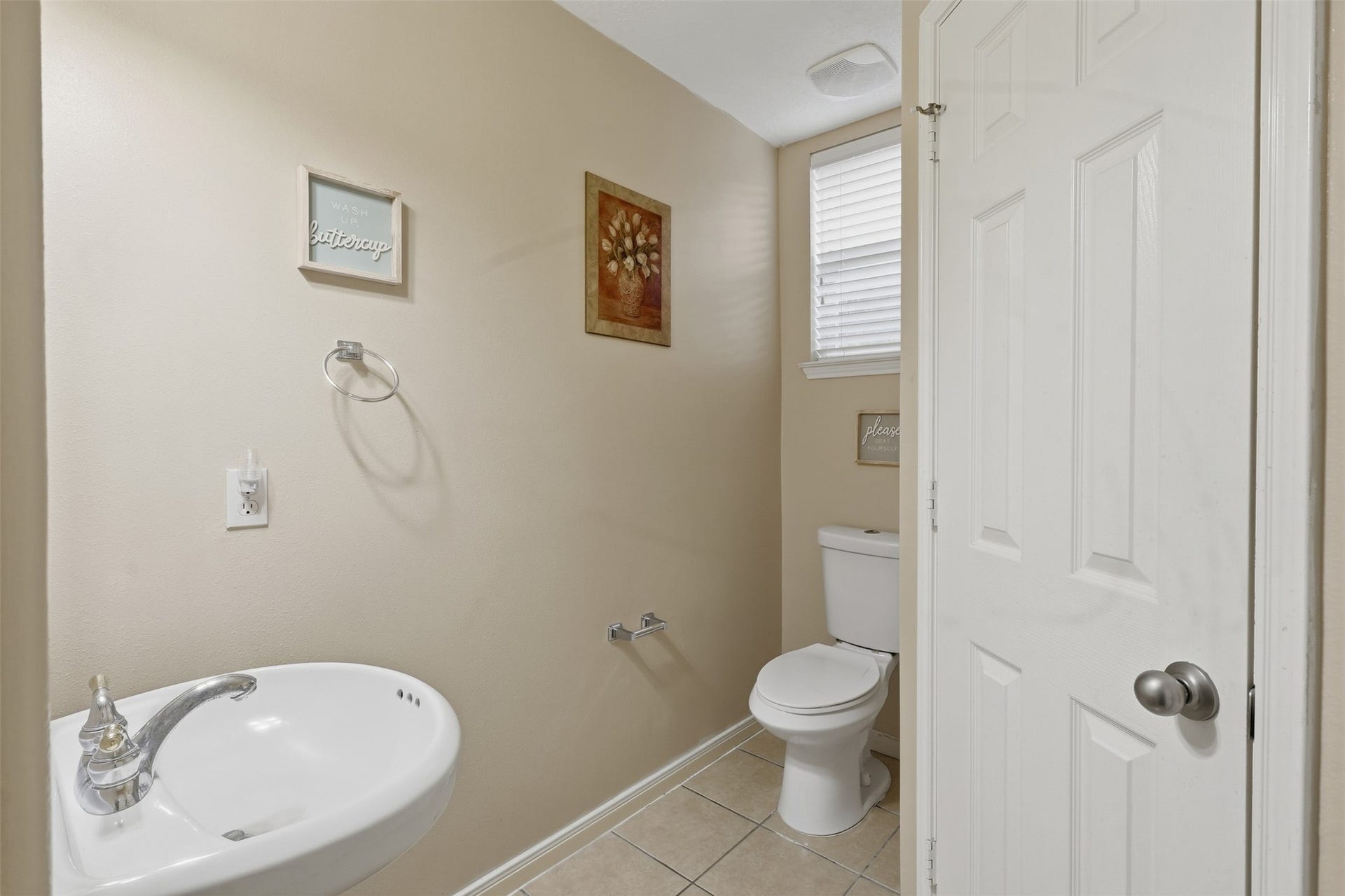 11404 Summit Bay Drive, Pearland, TX 77584 Convenient first-floor half bath features a clean, bright design with a pedestal sink, framed wall art, and tile flooringperfectly positioned for guests and everyday convenience.