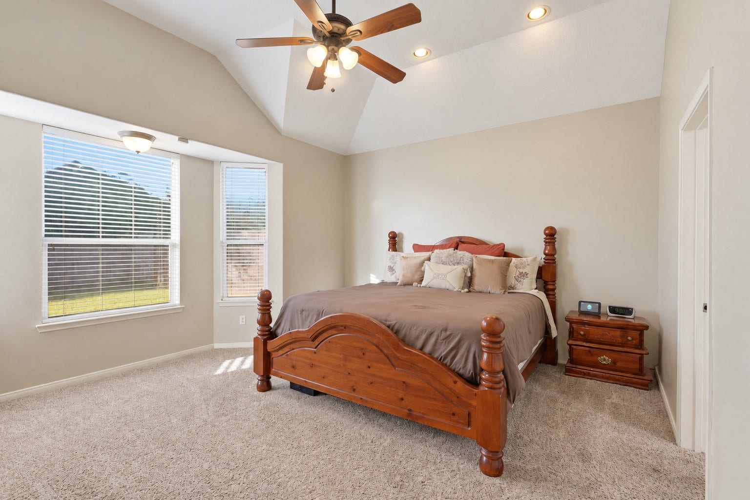 11404 Summit Bay Drive, Pearland, TX 77584 Spacious first-floor primary suite offers a peaceful retreat with plush carpeting, vaulted ceiling, ceiling fan, and large windows bringing in beautiful natural light in the sitting area. The generous layout provides plenty of space for a sitting area and comfortable furnishings.