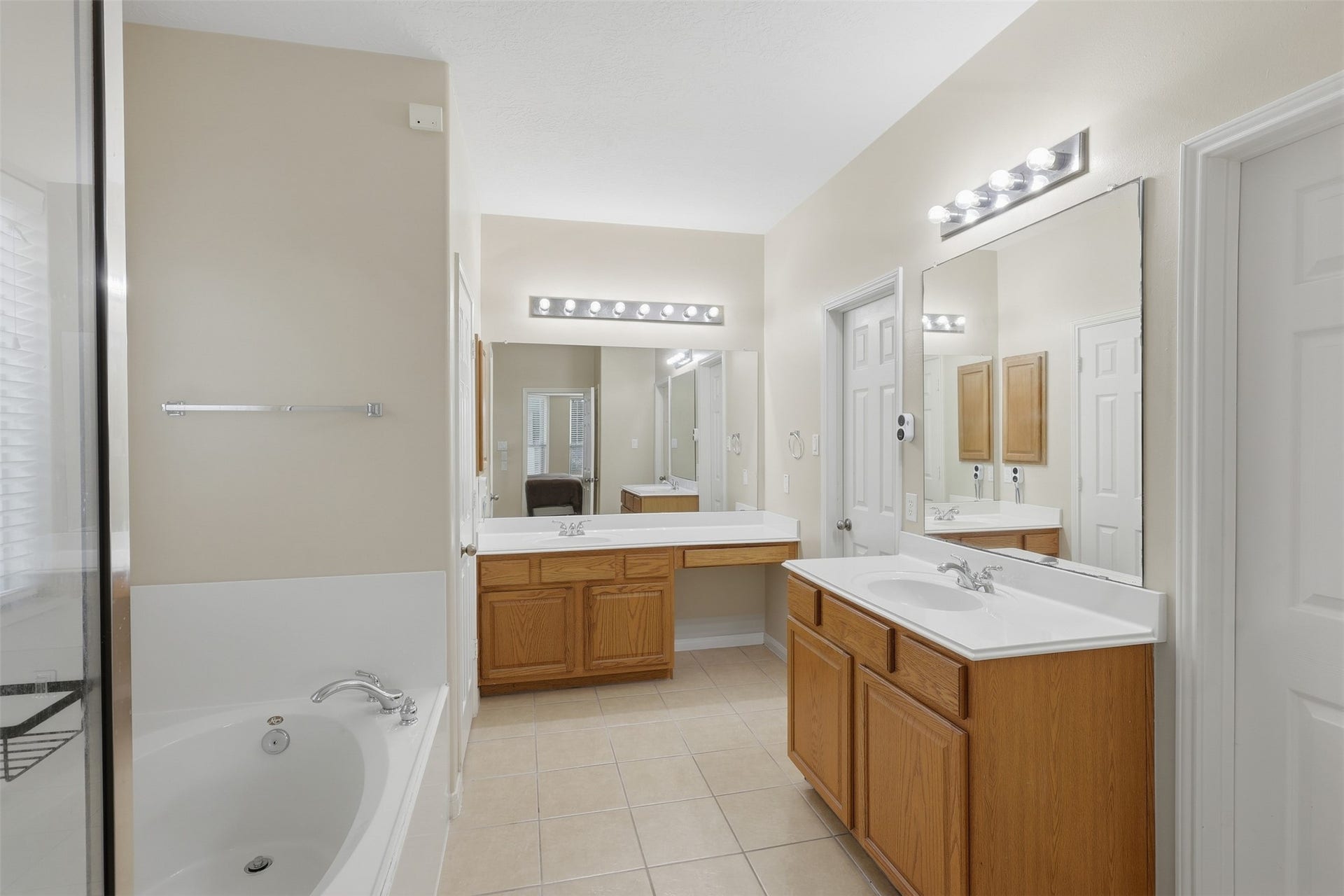 11404 Summit Bay Drive, Pearland, TX 77584 Beautiful primary bath offers a spa-like retreat with dual private vanities, generous cabinetry, large mirrors, soaking tub, and separate walk-in shower. Bright lighting and a spacious layout create a comfortable and relaxing start or end to your day.