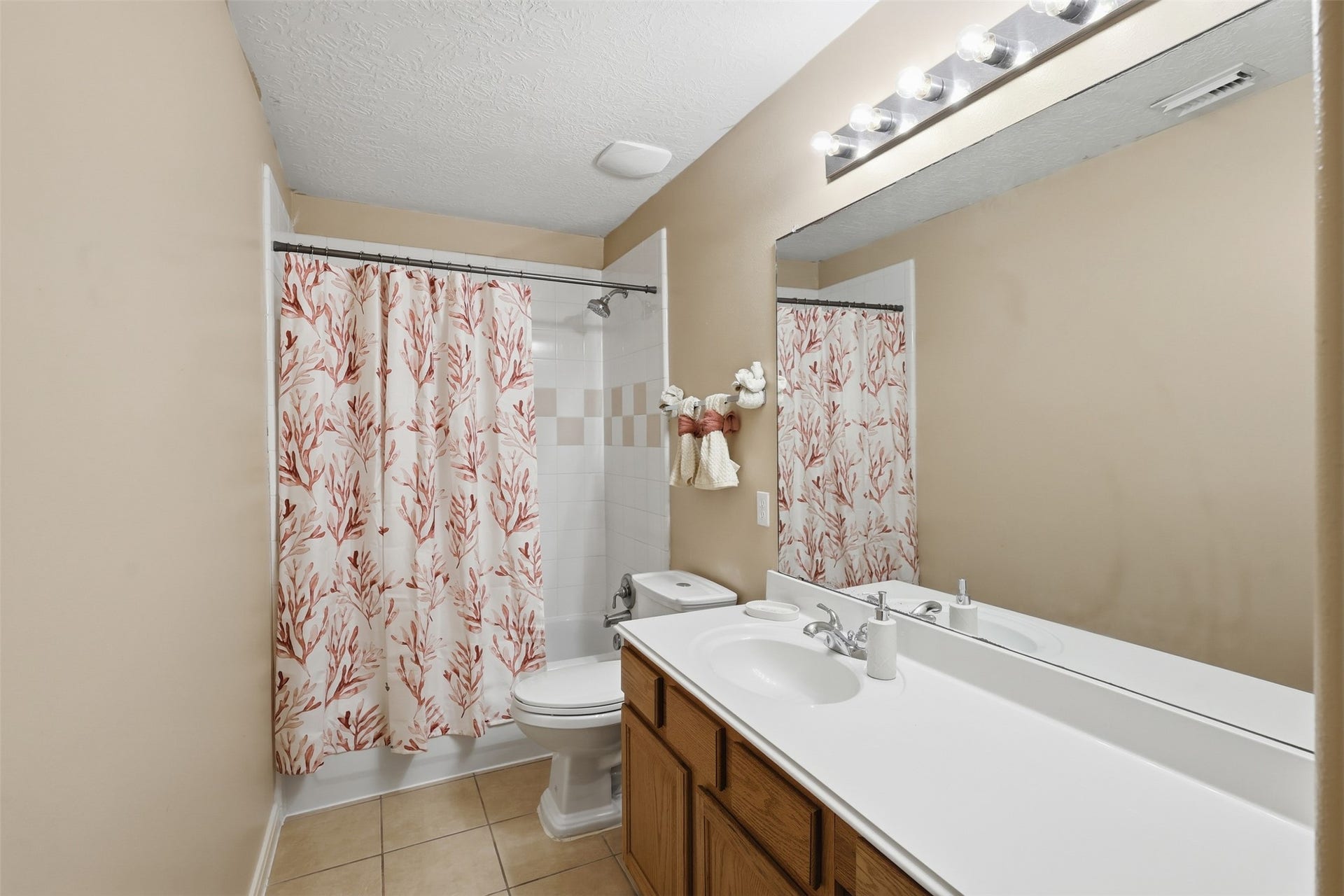 11404 Summit Bay Drive, Pearland, TX 77584 Bright secondary bathroom features a spacious vanity with ample counter space, large mirror, recessed lighting, and a tub/shower combination with decorative curtain. A clean and functional space designed for everyday convenience.