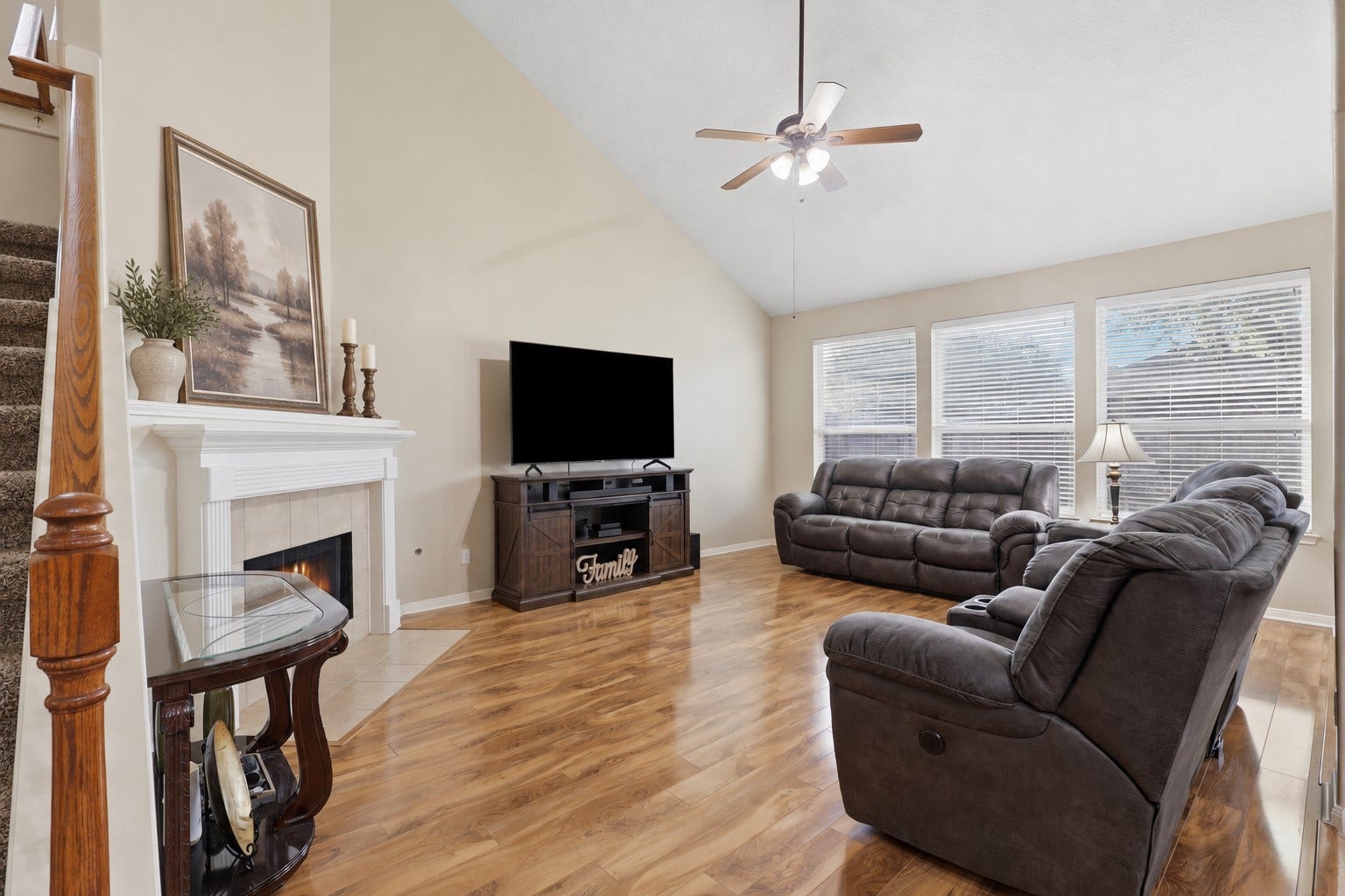 11404 Summit Bay Drive, Pearland, TX 77584 Warm and comfortable living space showcases the corner fireplace, soaring ceiling, ceiling fan, beautiful wood-look flooring, and large windows overlooking the backyard. Plenty of room for relaxing, movie nights, and gathering with family and friends.