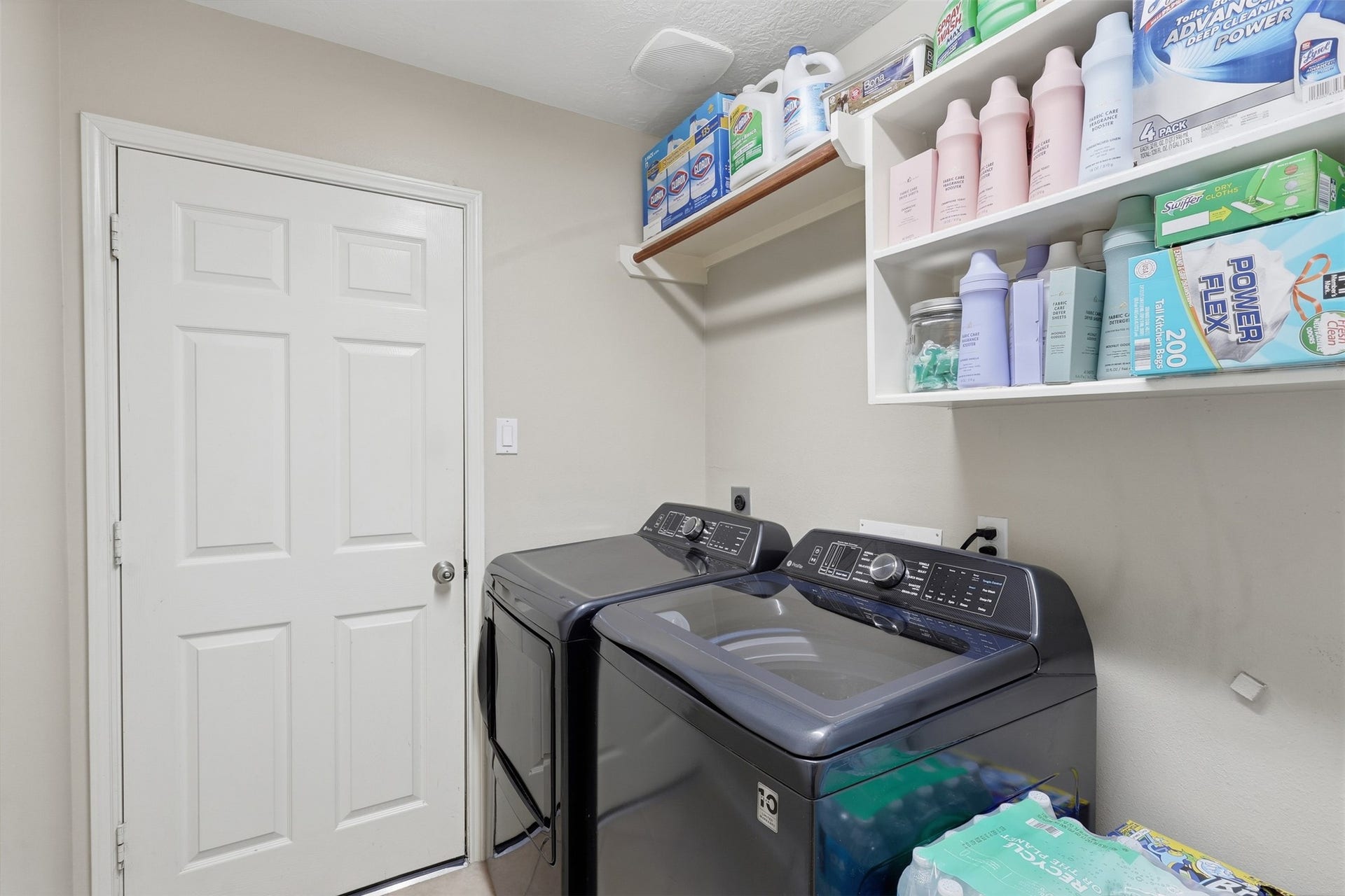 11404 Summit Bay Drive, Pearland, TX 77584 Convenient first-floor utility room features washer and dryer connections, overhead shelving for storage, and ample space for laundry essentials. A practical and organized workspace for everyday household needs.