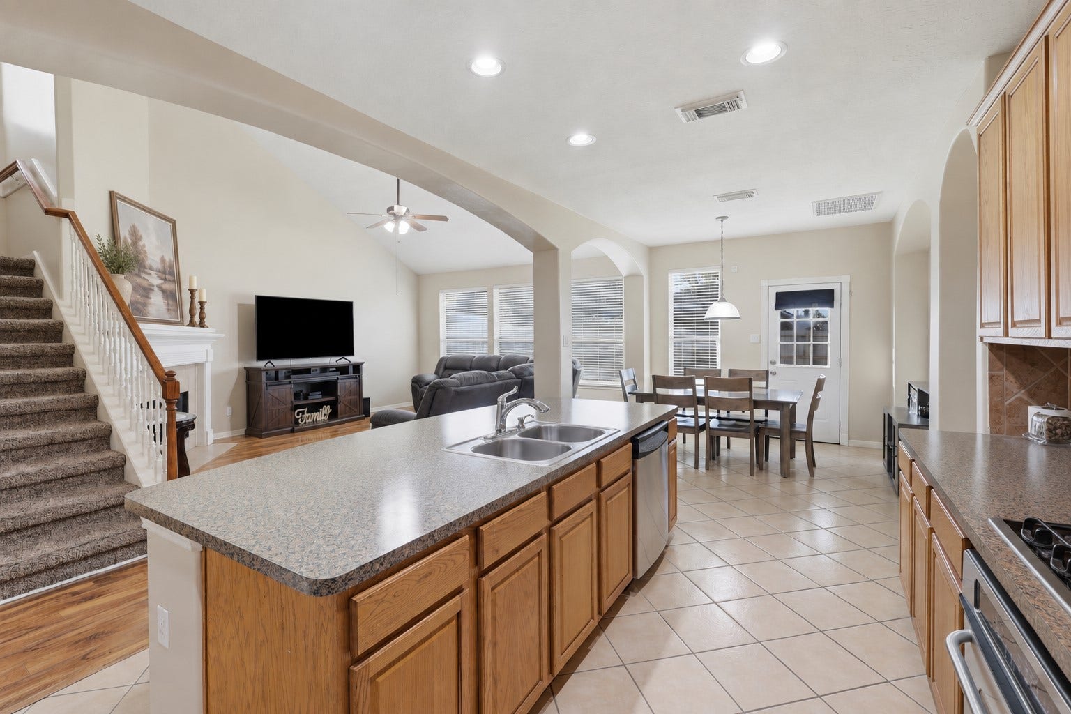 11404 Summit Bay Drive, Pearland, TX 77584 Spacious open-concept kitchen and family room create the perfect gathering space. The large island provides generous workspace and seating, while the kitchen flows seamlessly into the breakfast area and bright family room. Beautiful wood-look flooring and soaring ceilings add warmth and dimension.