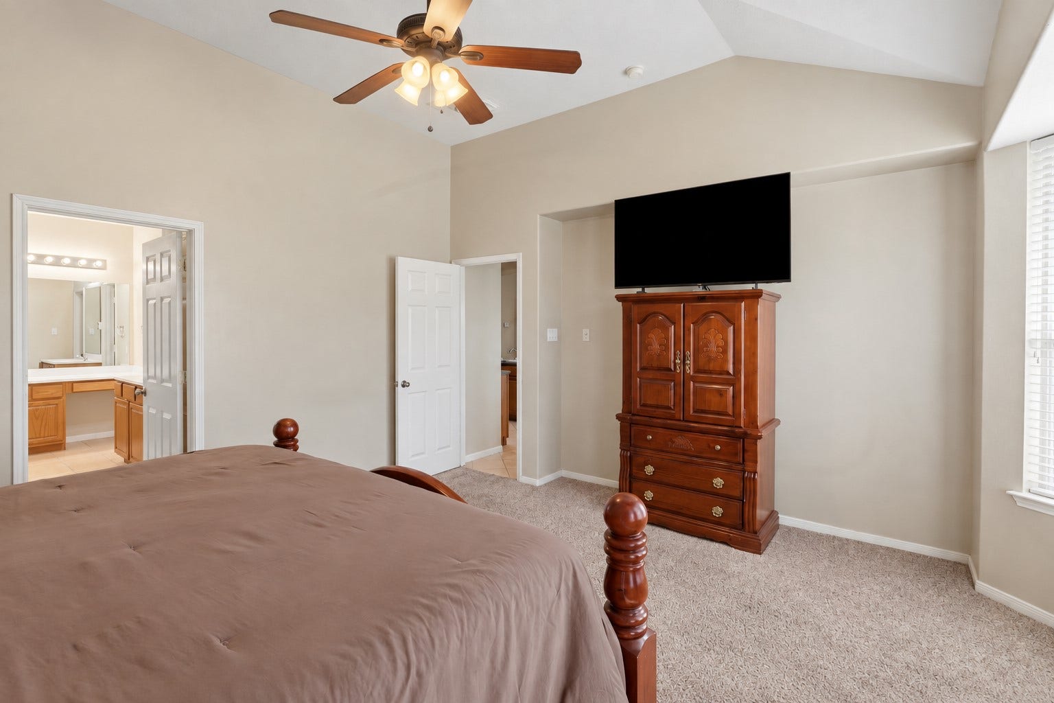 11404 Summit Bay Drive, Pearland, TX 77584 Another inviting view of the spacious primary suite showcases the vaulted ceiling, ceiling fan, large windows, and generous floor space. The bright, relaxing retreat offers plenty of room to unwind and connects conveniently to the luxurious primary bath.
