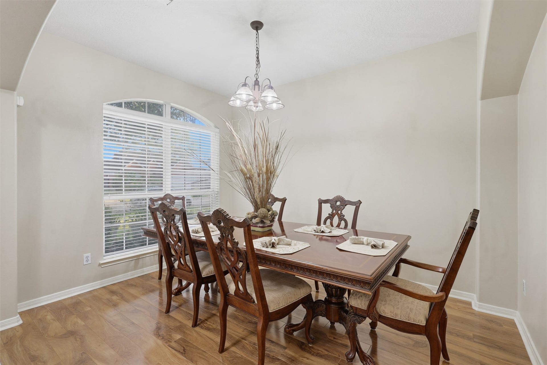 11404 Summit Bay Drive, Pearland, TX 77584 Gather in style in this bright and elegant formal dining room, where a large front window fills the space with natural light. Beautiful wood-look flooring, classic architectural arches, and a stunning chandelier create a warm and sophisticated atmosphere.