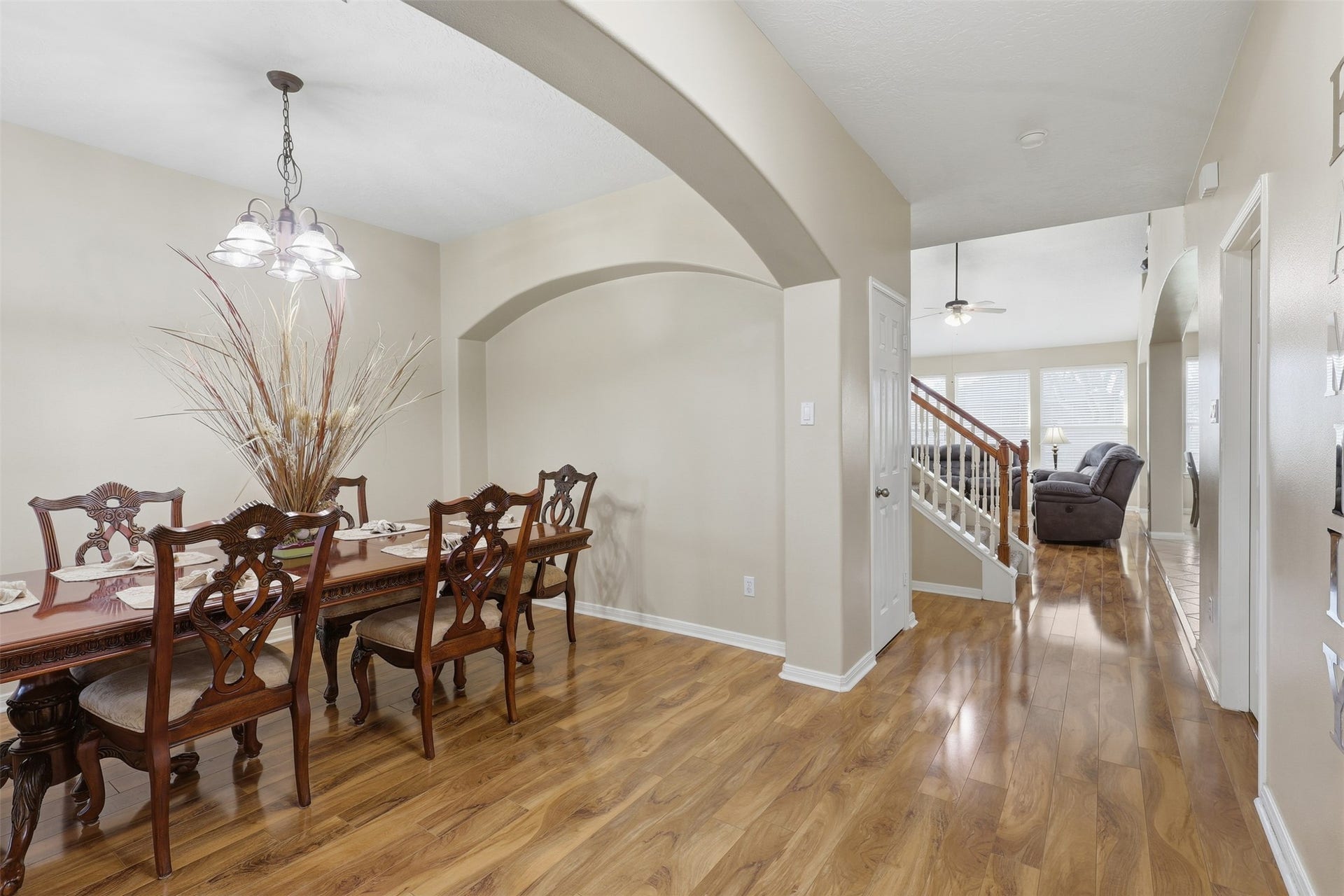 11404 Summit Bay Drive, Pearland, TX 77584 Step inside to an inviting formal dining room featuring rich wood-look flooring, elegant arched openings, soaring ceilings, and a beautiful chandelier. The open design creates a graceful setting for holiday dinners, celebrations, and memorable gatherings.