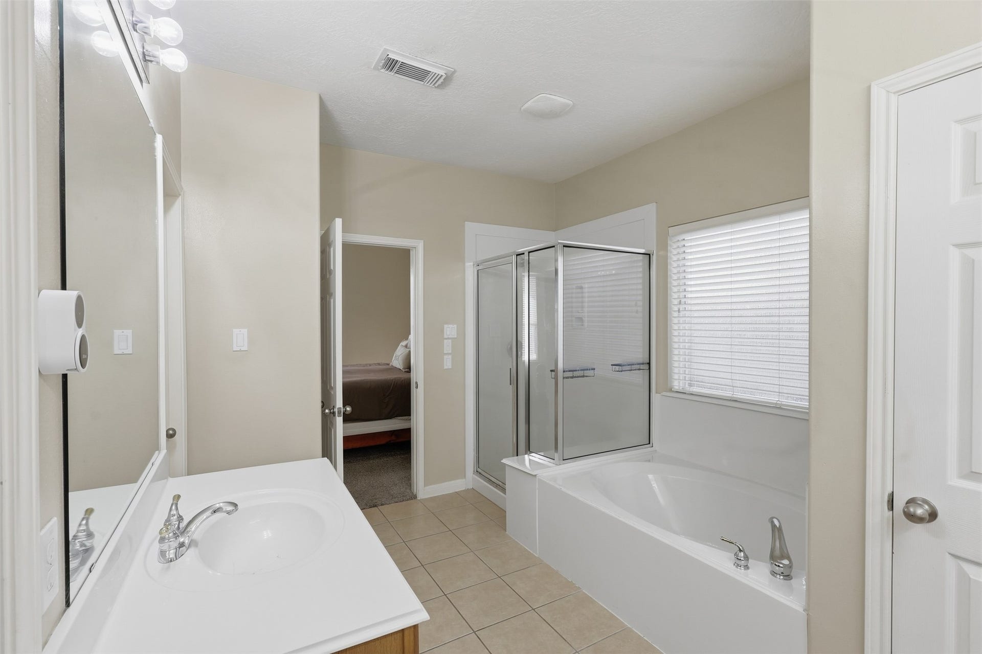 11404 Summit Bay Drive, Pearland, TX 77584 Another view of the spacious primary bath highlights the dual vanity, generous counter space, soaking tub, and separate walk-in shower. Neutral finishes and natural light create a bright, relaxing atmosphere.