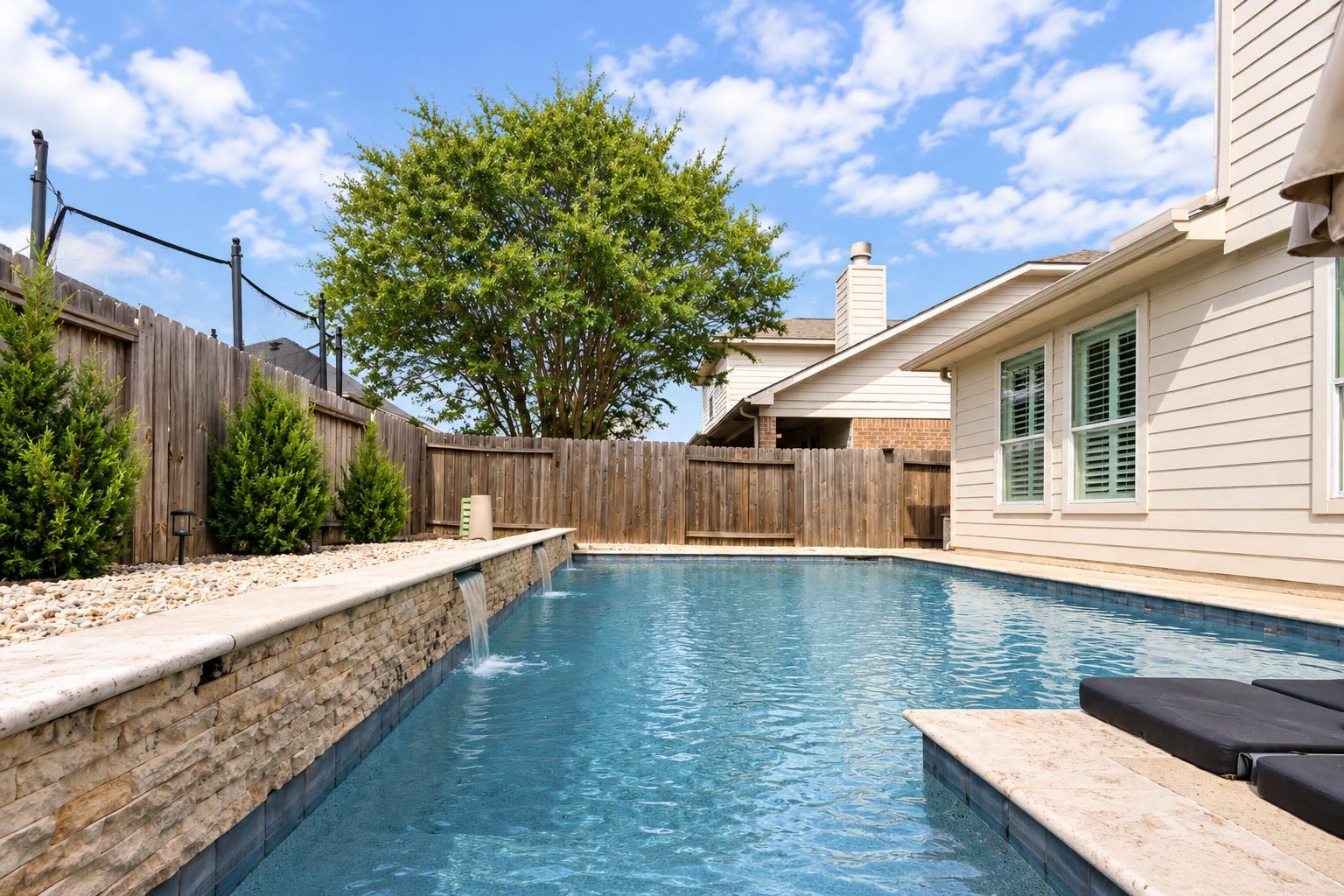 The backyard is highlighted by a sparkling PebbleTec pool installed in 2015, a durable finish designed for long-term enjoyment, along with a variable-speed pool pump installed in 2024 and iAquaLink app connectivity for convenient pool controls.