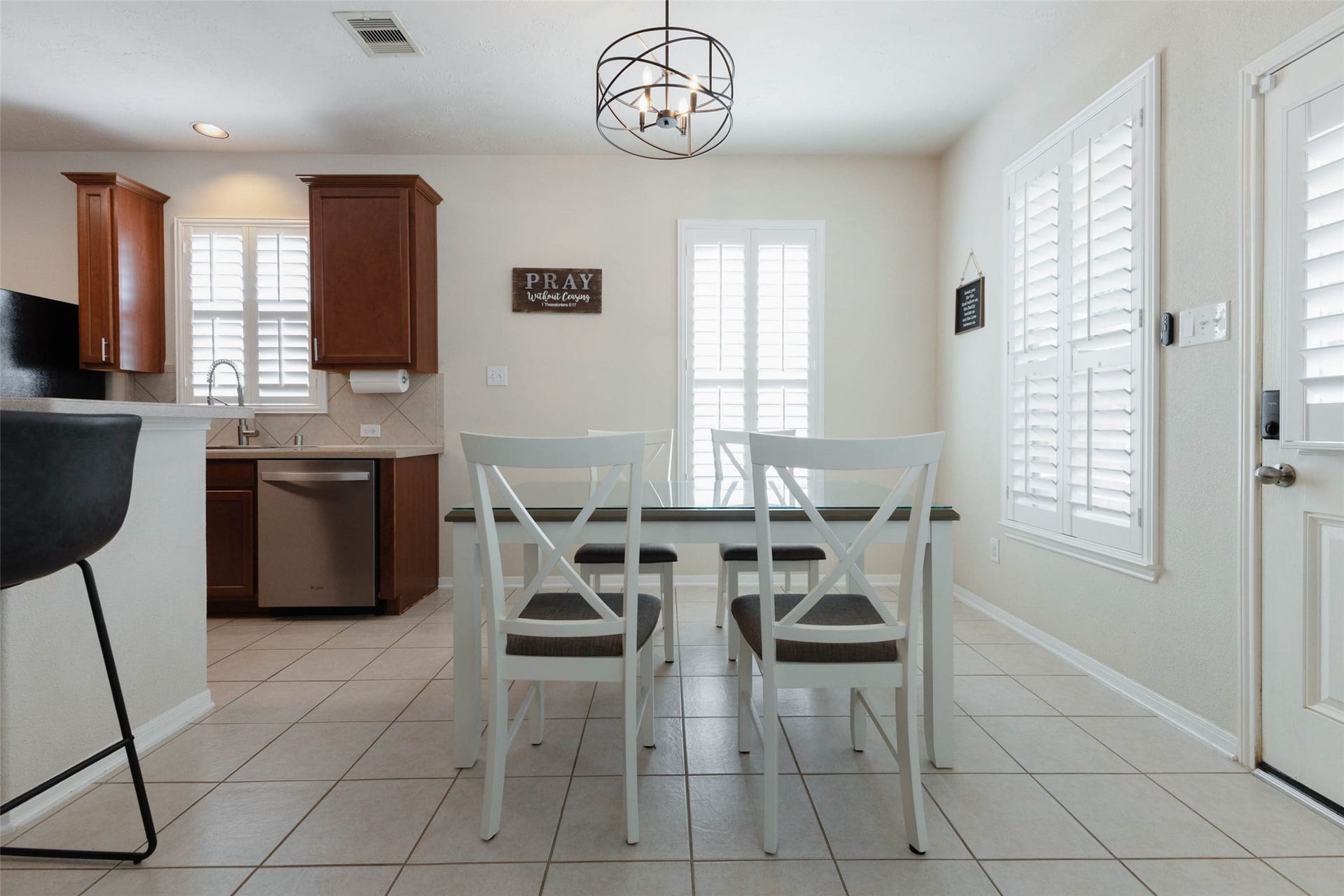 Bright and inviting, the breakfast area is surrounded by windows fitted with plantation shutters and finished with easy-care tile flooring. Its close connection to the kitchen keeps everyday meals convenient, while the nearby exterior door provides direct access to the backyard and pool.
