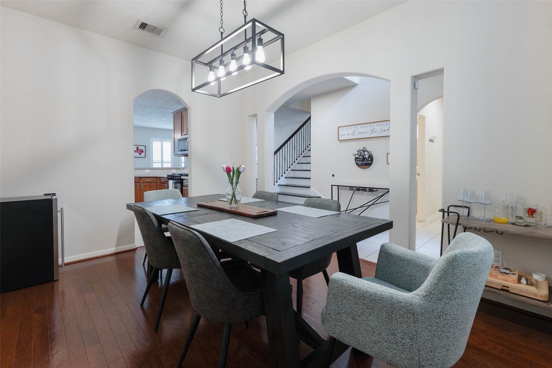 From this angle, the dining rooms generous proportions and graceful connection to the rest of the home are on full display. Arched openings lead toward the entry and kitchen while allowing the room to maintain its own distinct character.