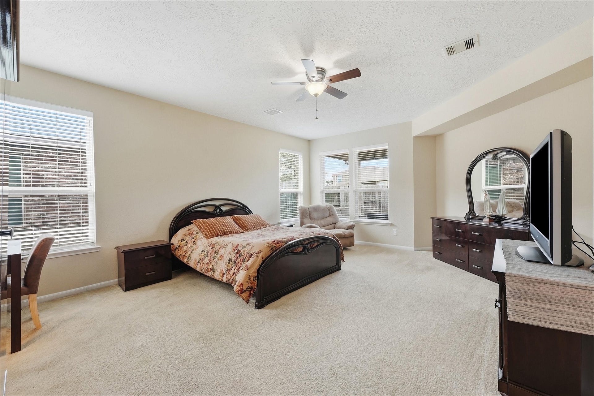 25522 Brentmoor Drive, Porter, TX 77365 Sprawling primary suite with plush carpeting and natural light, featuring a flexible window nook perfect for a nursery area, nursing space, or reading corner.