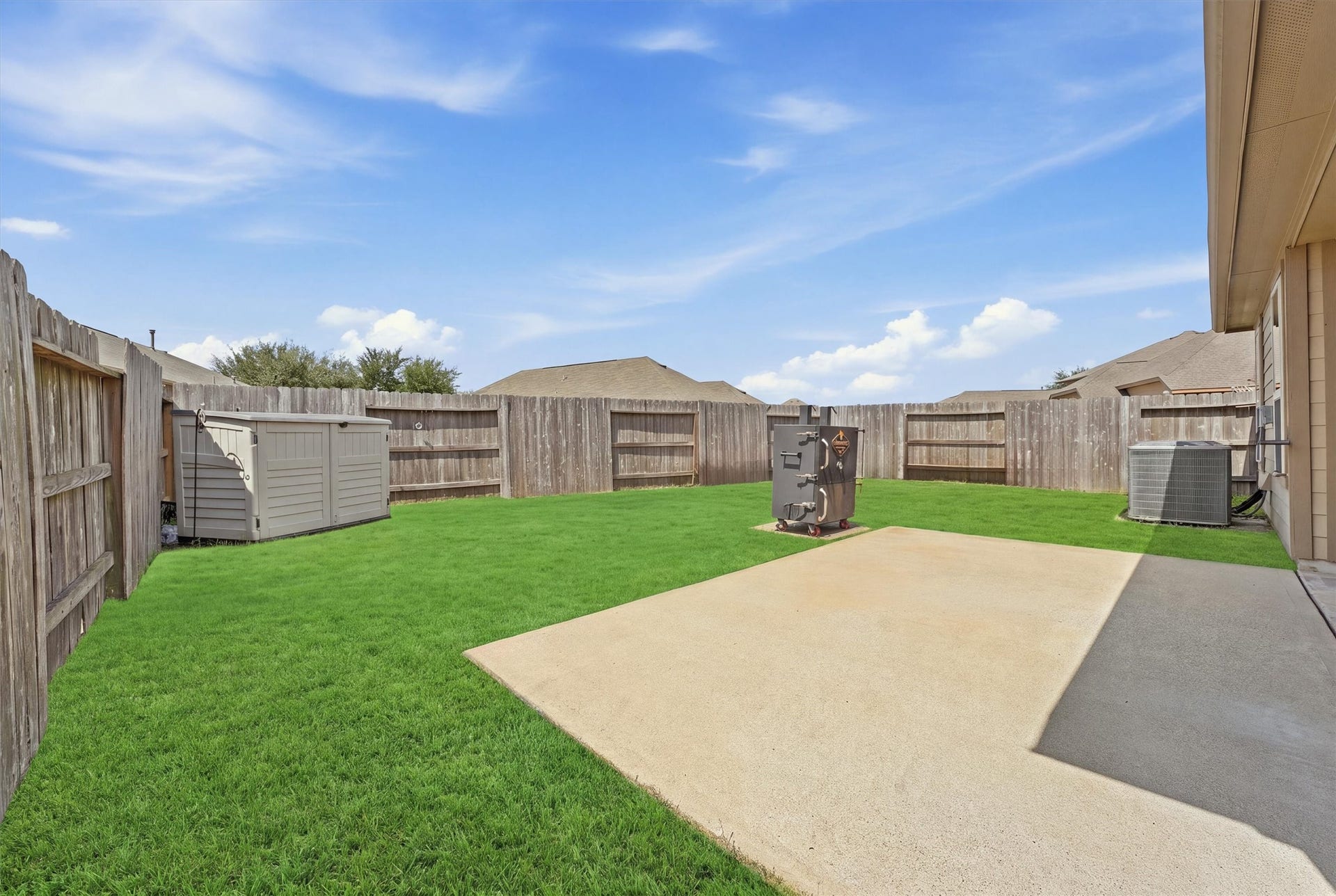 25522 Brentmoor Drive, Porter, TX 77365 Massive fully fenced backyard featuring an extended concrete patio pad perfect for grilling, outdoor dining, and plenty of green lawn space for play or a future pool.