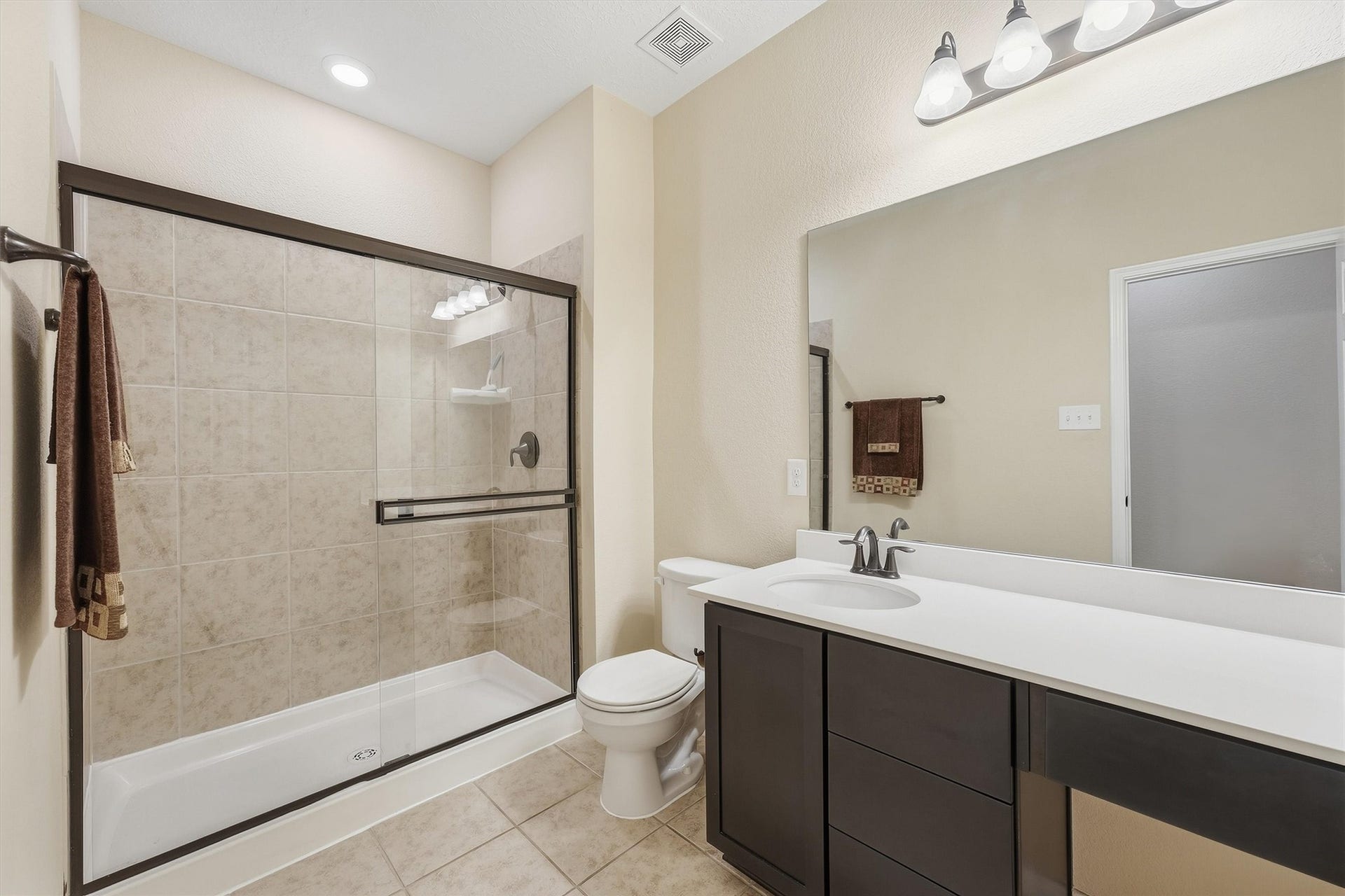 25522 Brentmoor Drive, Porter, TX 77365 Well-appointed bath complete with modern vanity lighting, large frameless mirror, ample counter space, and an easy-access walk-in shower with sliding glass doors.