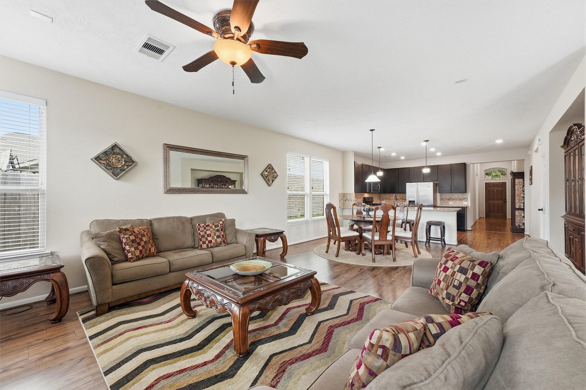 25522 Brentmoor Drive, Porter, TX 77365 Spacious, light-filled family room featuring wood-look flooring, a lighted ceiling fan, multiple picture windows, and direct glass-door access to the backyard.