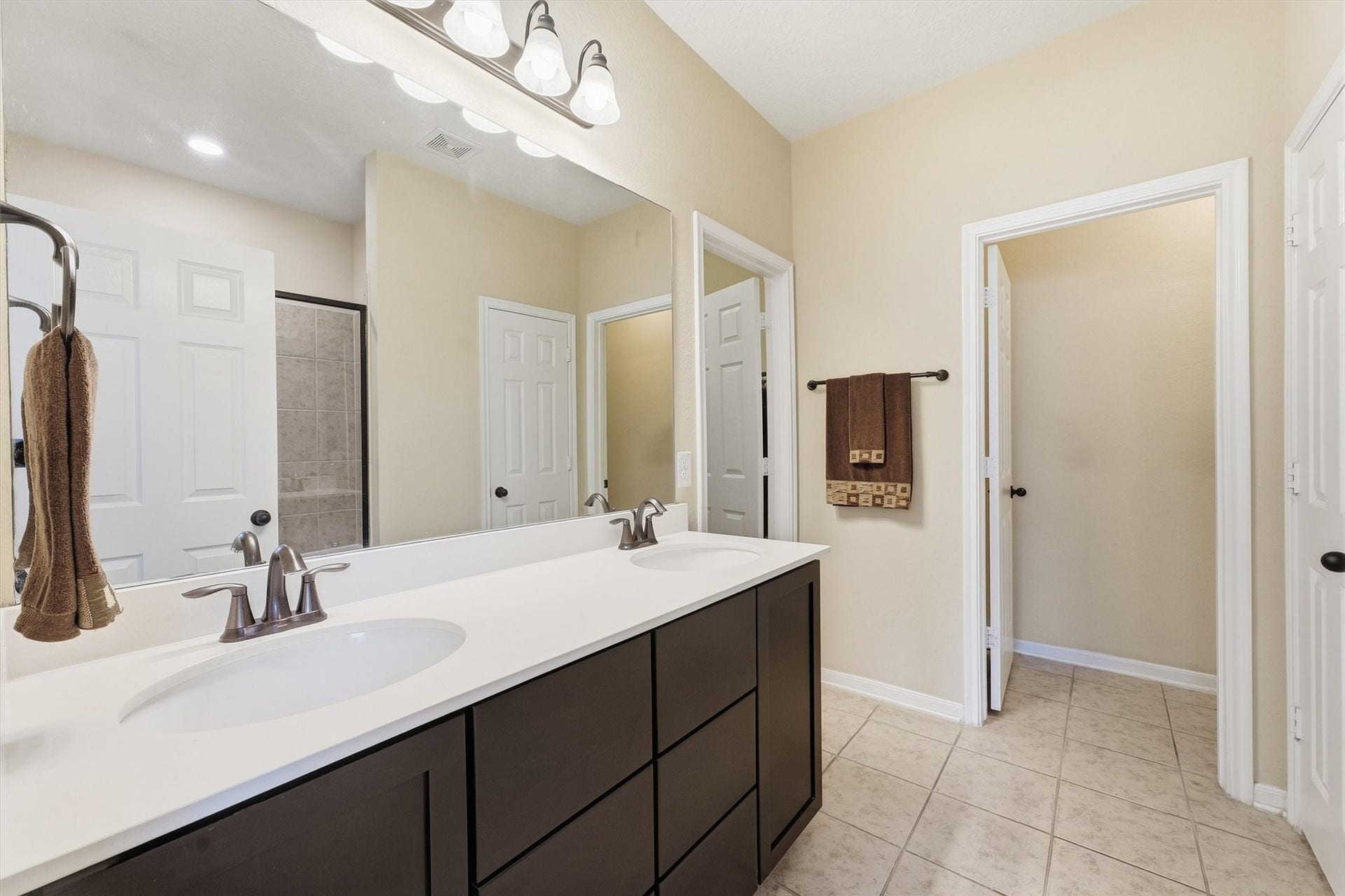 25522 Brentmoor Drive, Porter, TX 77365 Primary bath vanity showcases sleek brushed fixtures, an oversized mirror with modern lighting, and ample dark cabinetry for effortless organization.