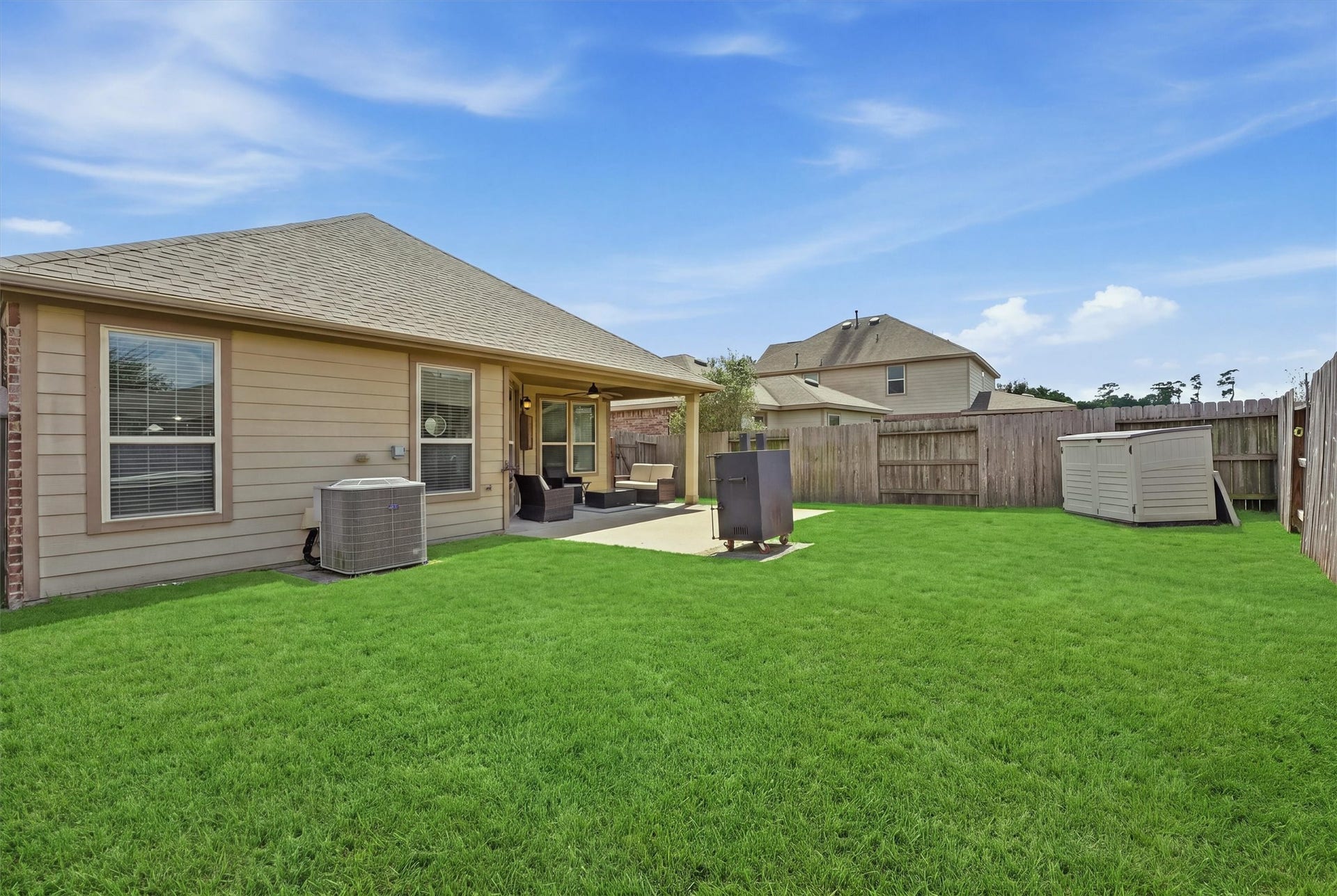 25522 Brentmoor Drive, Porter, TX 77365 Massive fully fenced backyard featuring an extended concrete patio pad perfect for grilling, outdoor dining, and plenty of green lawn space for play or a future pool.