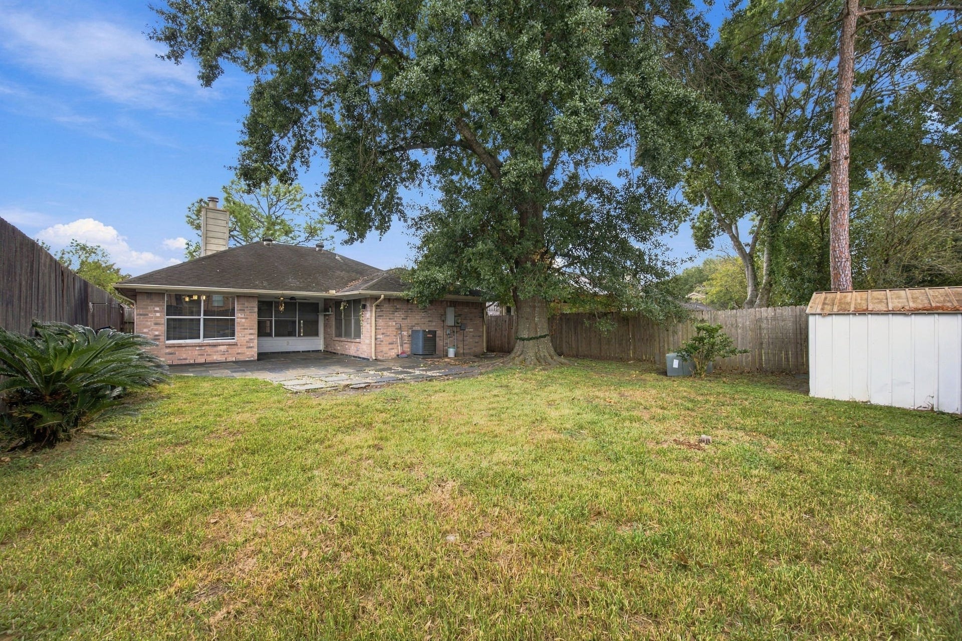 12902 Sandri Lane, Houston, TX 77077 A spacious, fenced backyard offers room for gardening, outdoor activities, and entertaining.