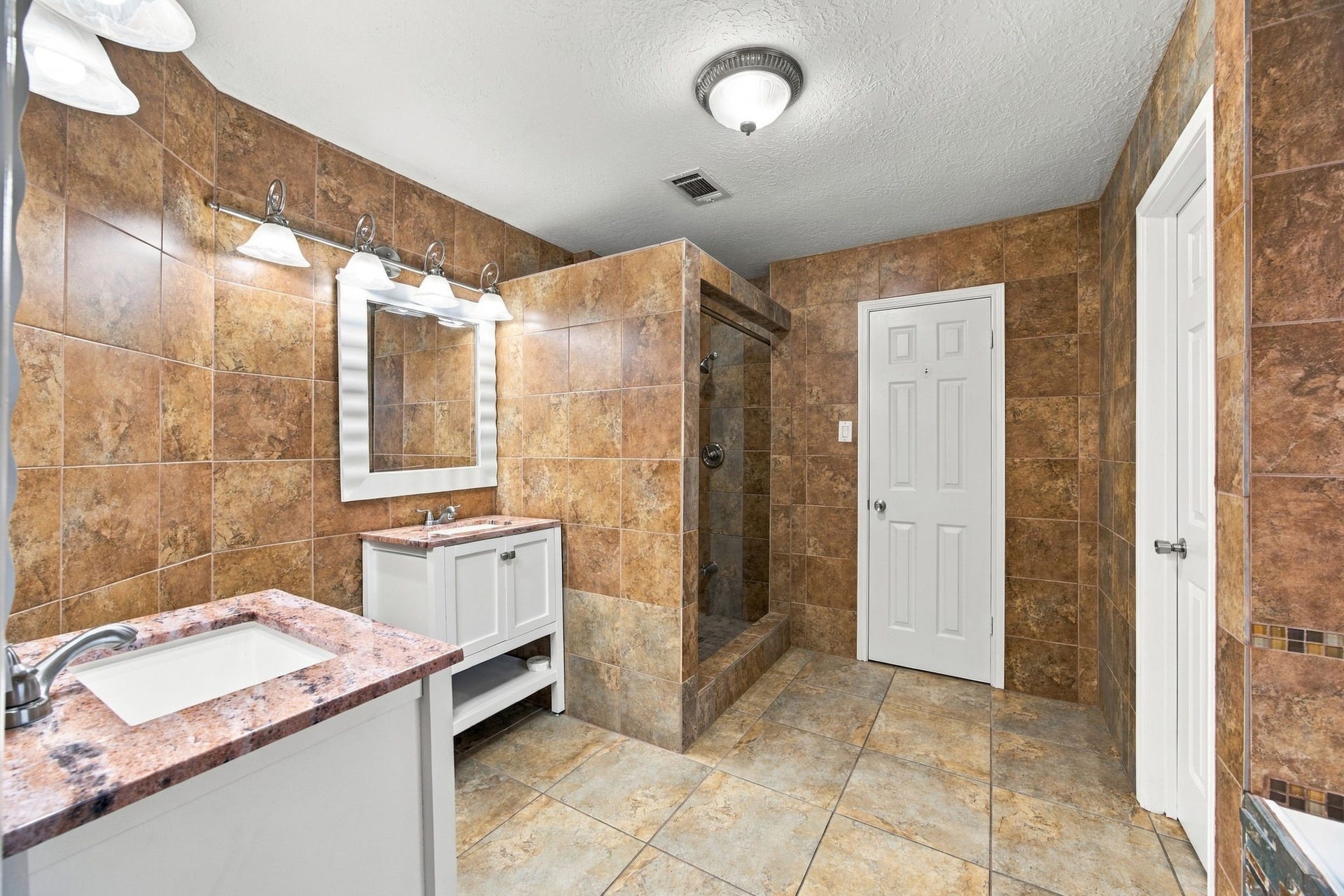 12902 Sandri Lane, Houston, TX 77077 Two individual vanities provide dedicated space for daily routines, each with its own mirror and lighting.