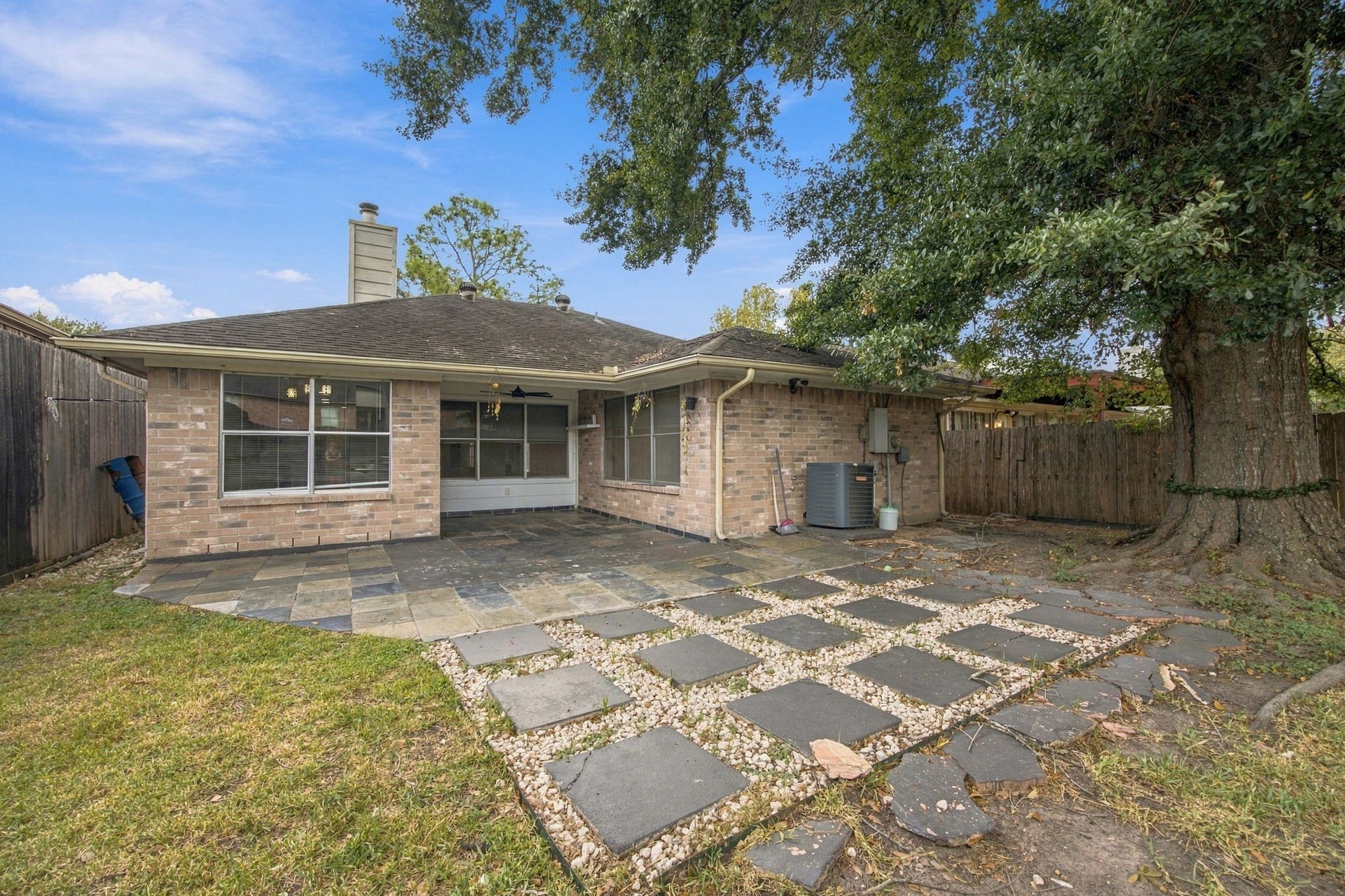 12902 Sandri Lane, Houston, TX 77077 The brick exterior overlooks an extended patio with a decorative paver-and-gravel design.