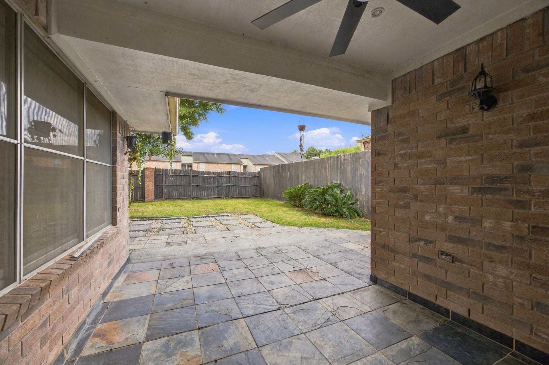 12902 Sandri Lane, Houston, TX 77077 Enjoy a shaded outdoor seating area with tile flooring, a ceiling fan, and views of the backyard.