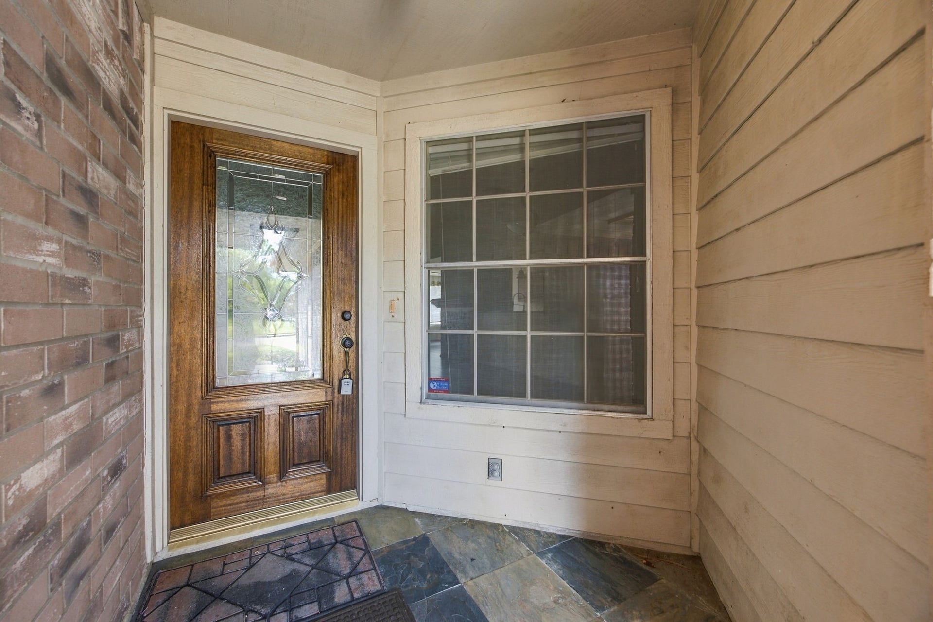 12902 Sandri Lane, Houston, TX 77077 A sheltered front entry features tile flooring and a wood door with decorative glass.