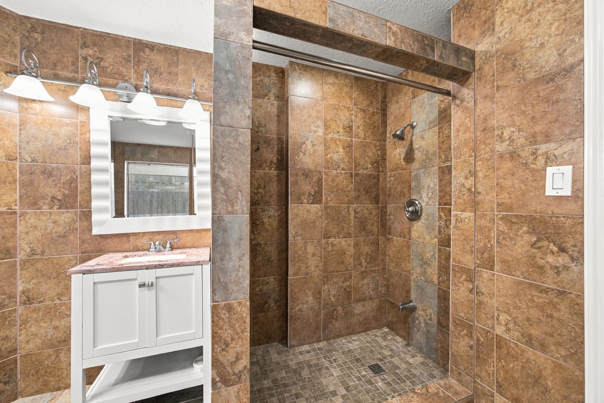 12902 Sandri Lane, Houston, TX 77077 The walk-in shower features floor-to-ceiling tile and a mosaic tile floor.