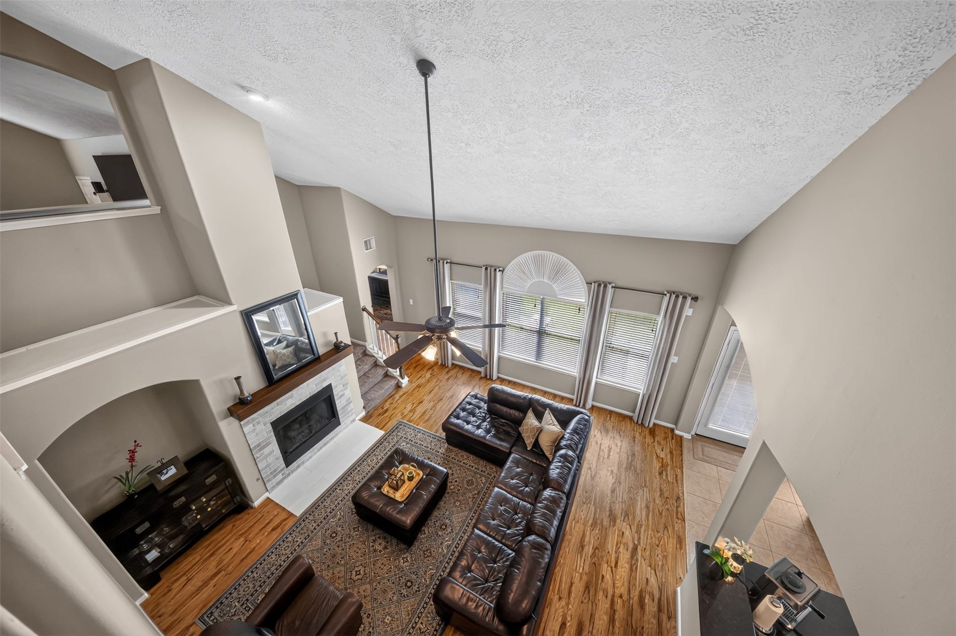127 N Hawthorne Hollow Circle, The Woodlands, TX 77384 Birds-eye view highlights the soaring ceilings, abundant natural light, updated fireplace, and open flow of the main living area.