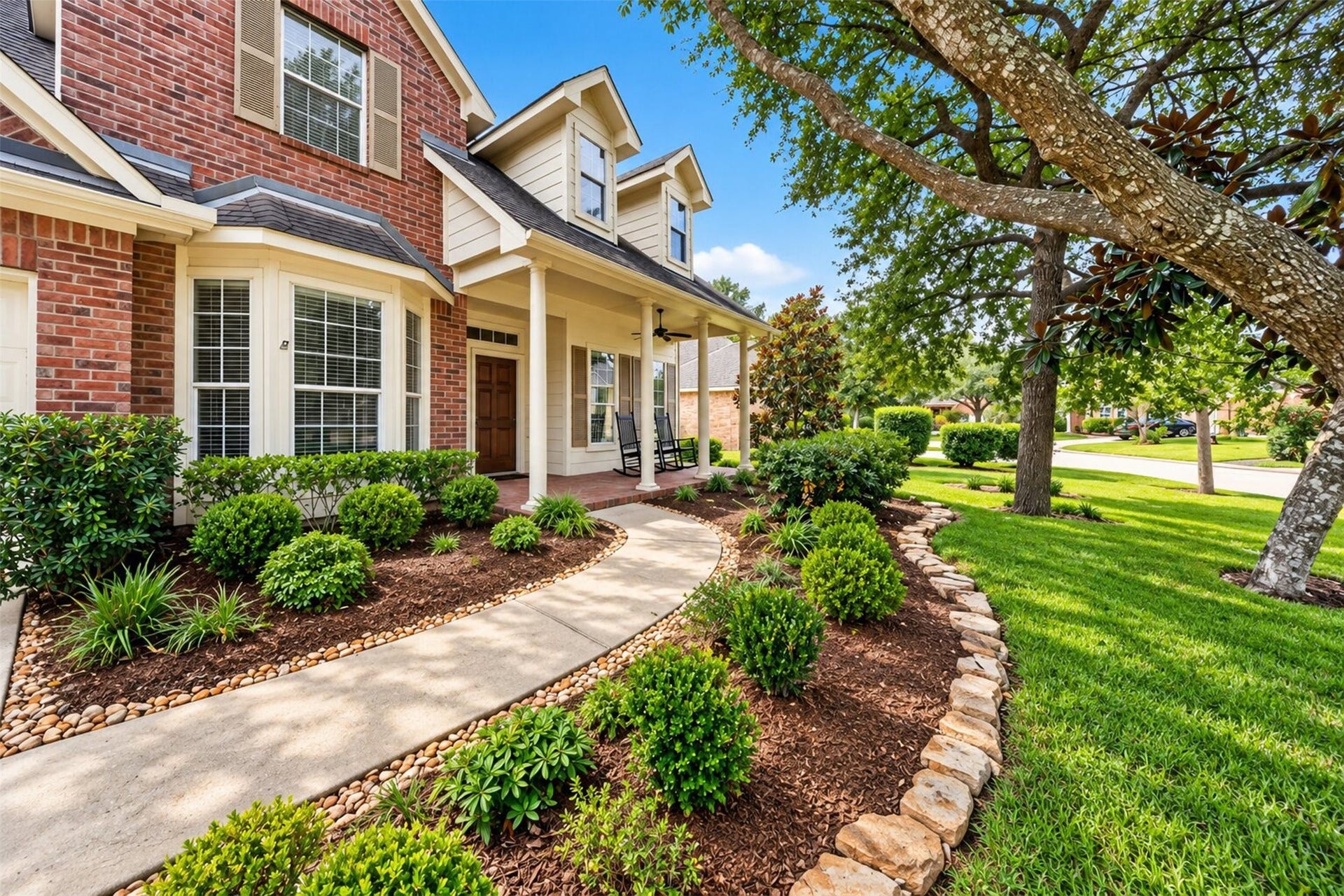 127 N Hawthorne Hollow Circle, The Woodlands, TX 77384 Beautiful curb appeal framed by mature trees, lush landscaping, and a welcoming walkway leading to the covered front porch.