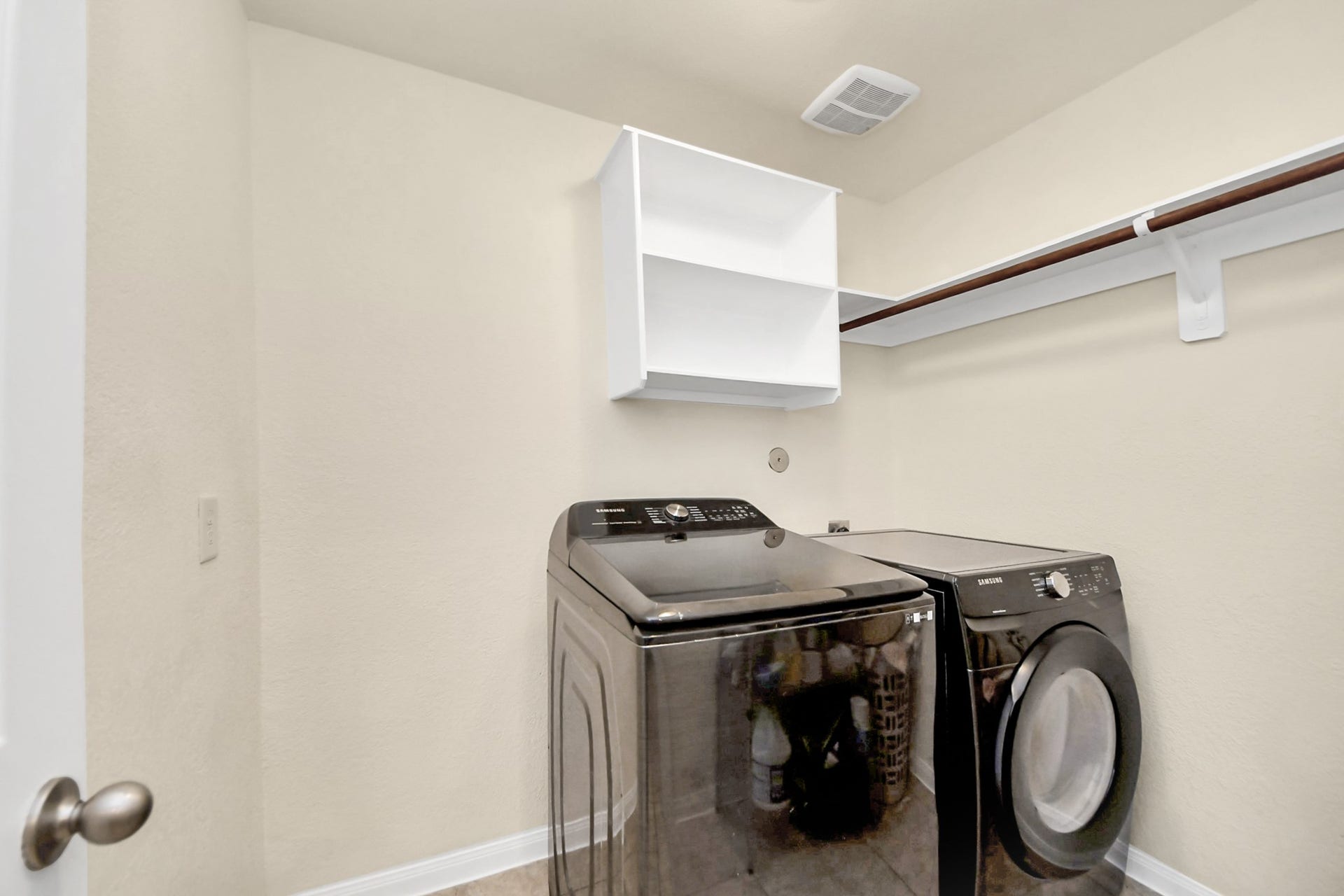 12906 Millstream Bend Lane, Tomball, TX 77377 Spacious laundry room with modern washer and dryer, ample shelving, and hanging space for convenience.