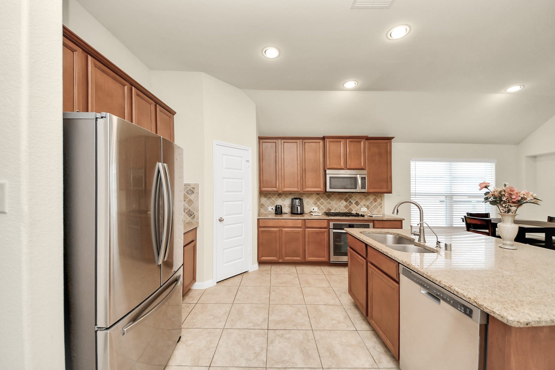 12906 Millstream Bend Lane, Tomball, TX 77377 Spacious kitchen with stainless steel appliances, elegant wooden cabinetry, and a large granite island perfect for entertaining.