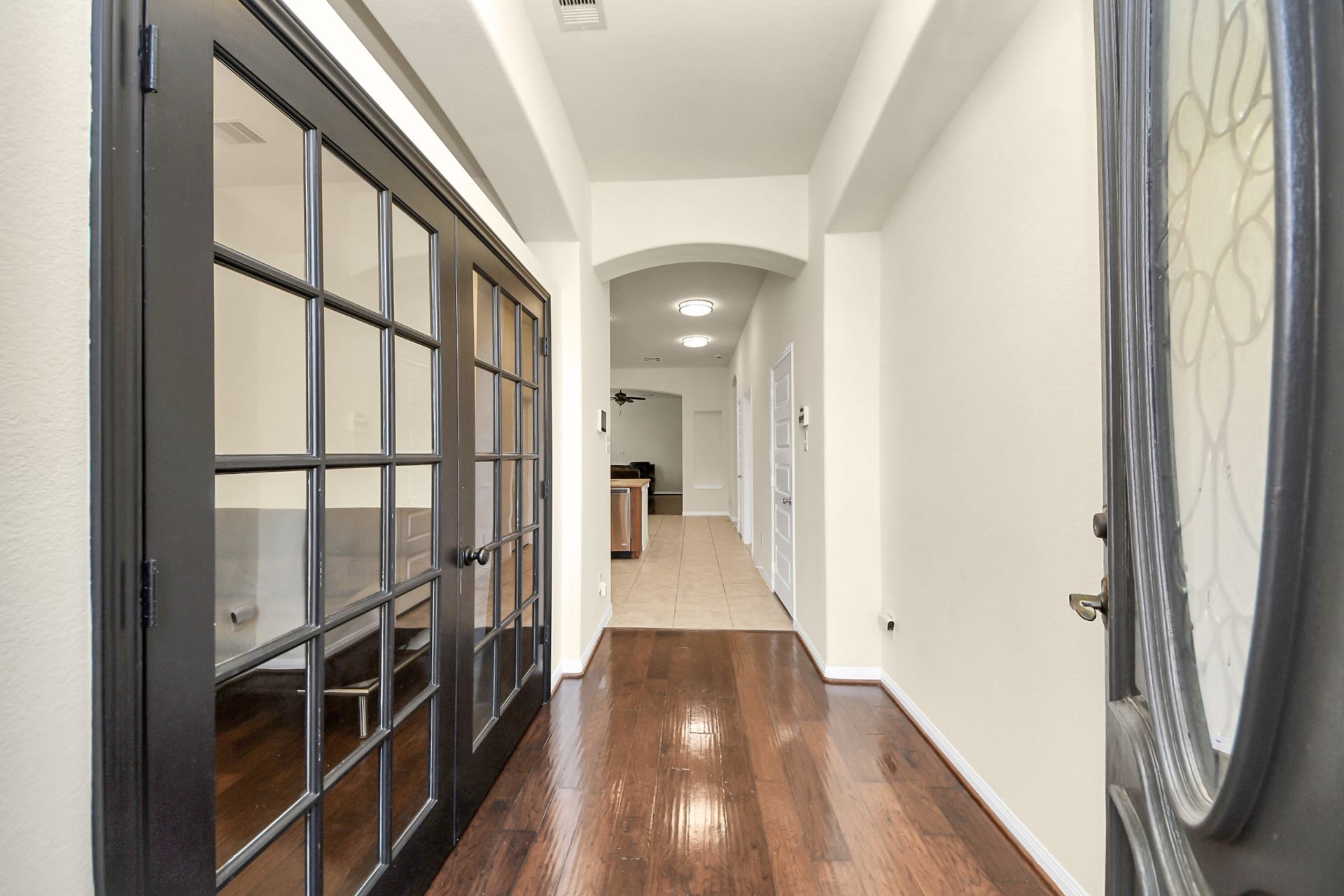 12906 Millstream Bend Lane, Tomball, TX 77377 Elegant entryway featuring rich hardwood floors and stylish glass-paneled doors, leading into a spacious, well-lit interior.