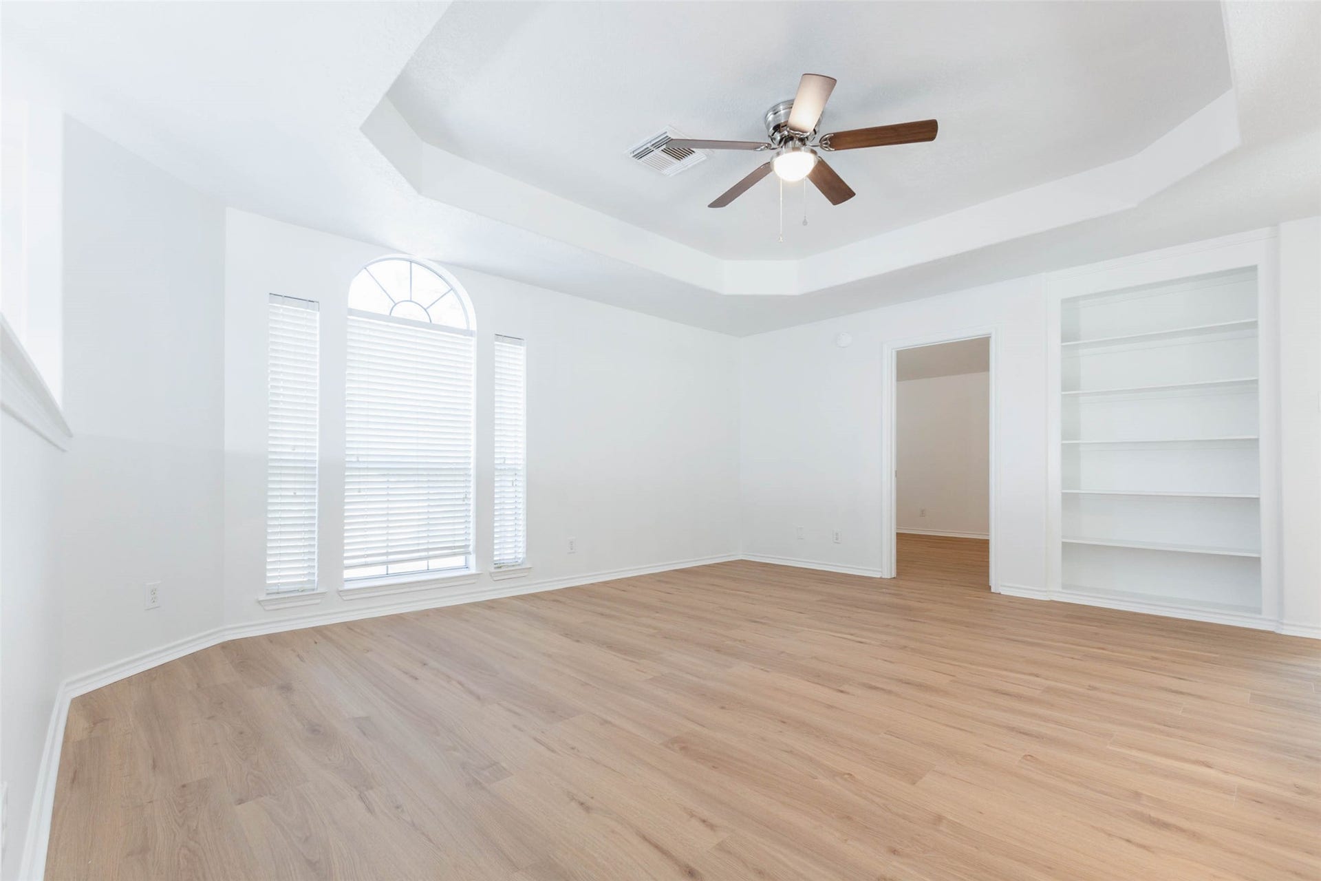 6302 Briar Canyon Court, Katy, TX 77450 The expansive upstairs game room offers a fabulous secondary living space, featuring gorgeous luxury vinyl plank flooring, an elegant tray ceiling, & a ceiling fan. Generous windows welcome abundant natural light, while built-in shelving adds character & functionality.