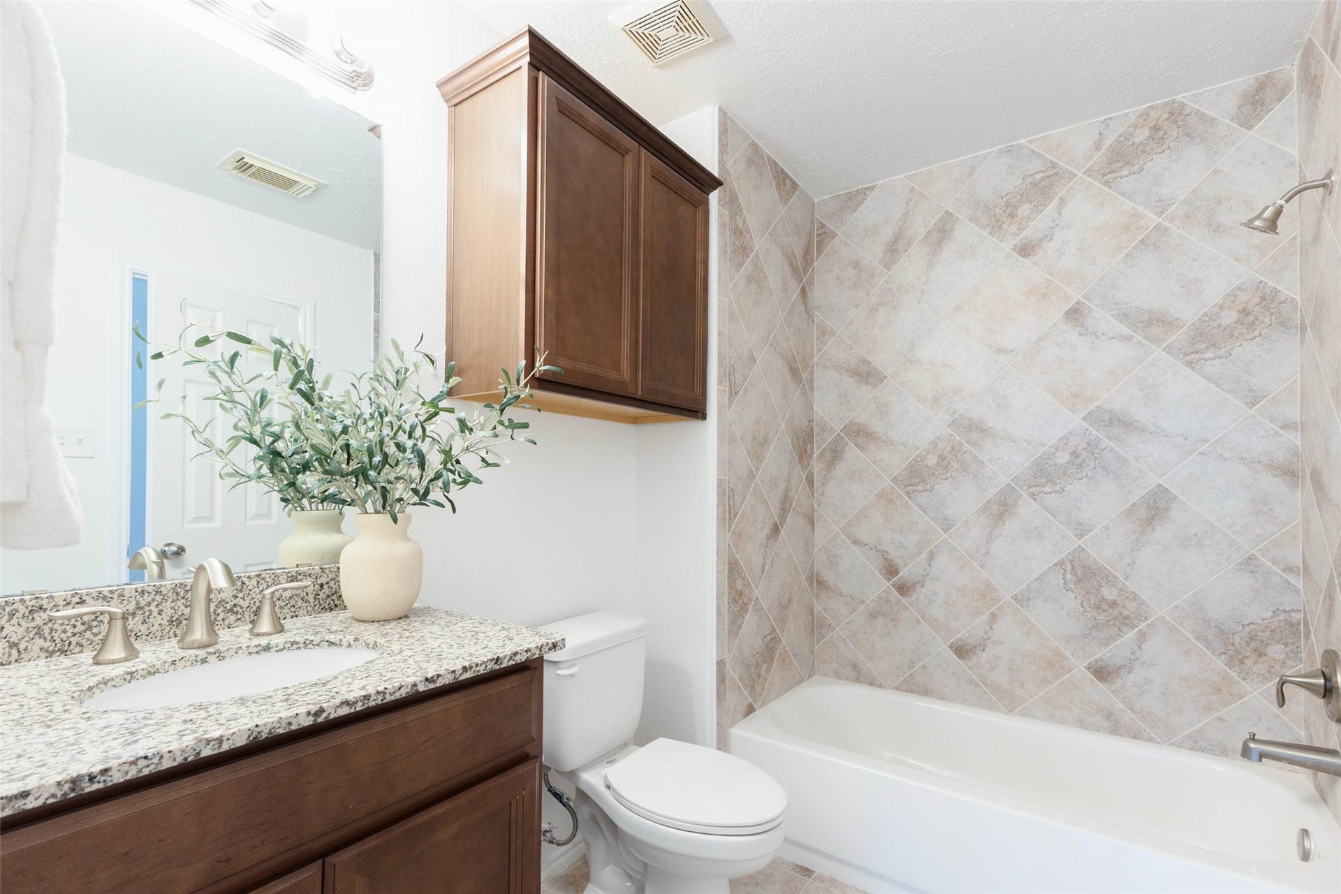 6302 Briar Canyon Court, Katy, TX 77450 This well-appointed secondary bathroom features a generous granite-topped vanity with rich wood cabinetry offering ample storage. An oversized mirror & attractive overhead lighting complement the warm finishes, while a tub/shower combo completes the inviting, functional design.