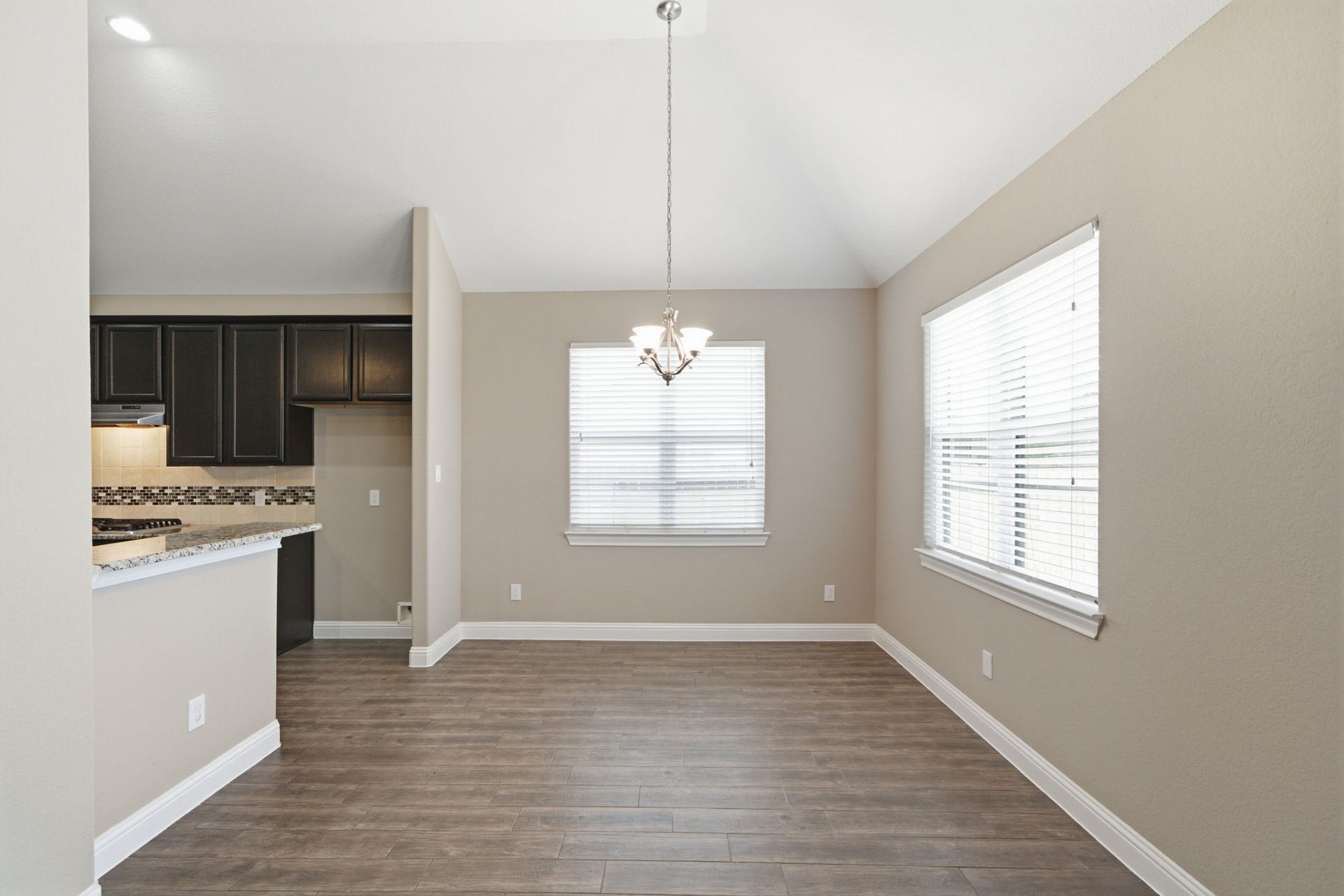 18818 Wichita Trail, Magnolia, TX 77355 Flooring of durable wood-look tile runs throughout this open dining area, positioned adjacent to the kitchen for effortless serving. Vaulted ceilings and wide windows create a spacious feel, comfortably hosting a table for four to six guests.