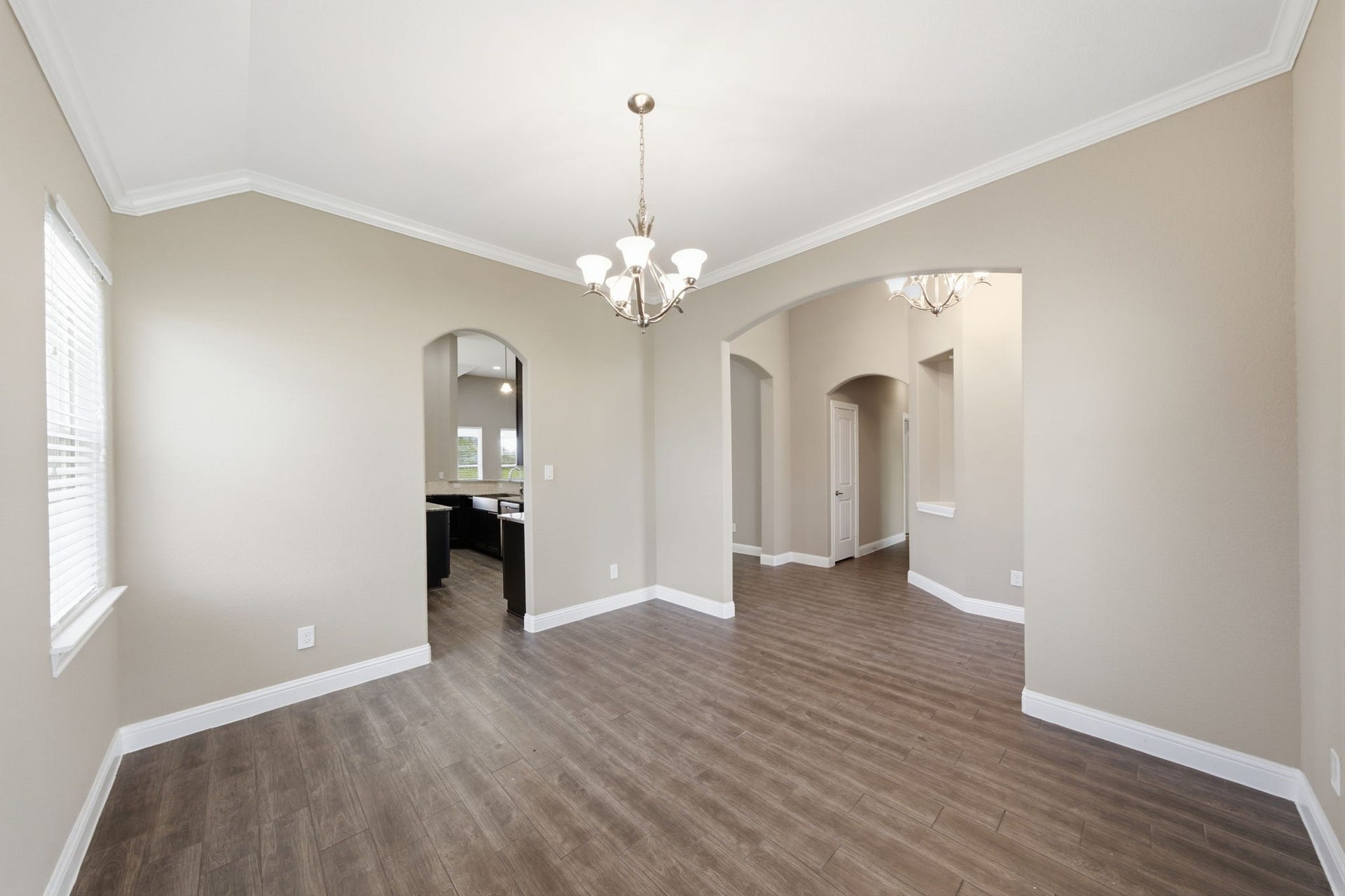 18818 Wichita Trail, Magnolia, TX 77355 Centered around a large dining table, this formal dining space boasts a high vaulted ceiling, neutral wall paint, and wood-look tile flooring. Elegant arched doorways connect the area to the foyer and kitchen, while a wide window allows for natural light.