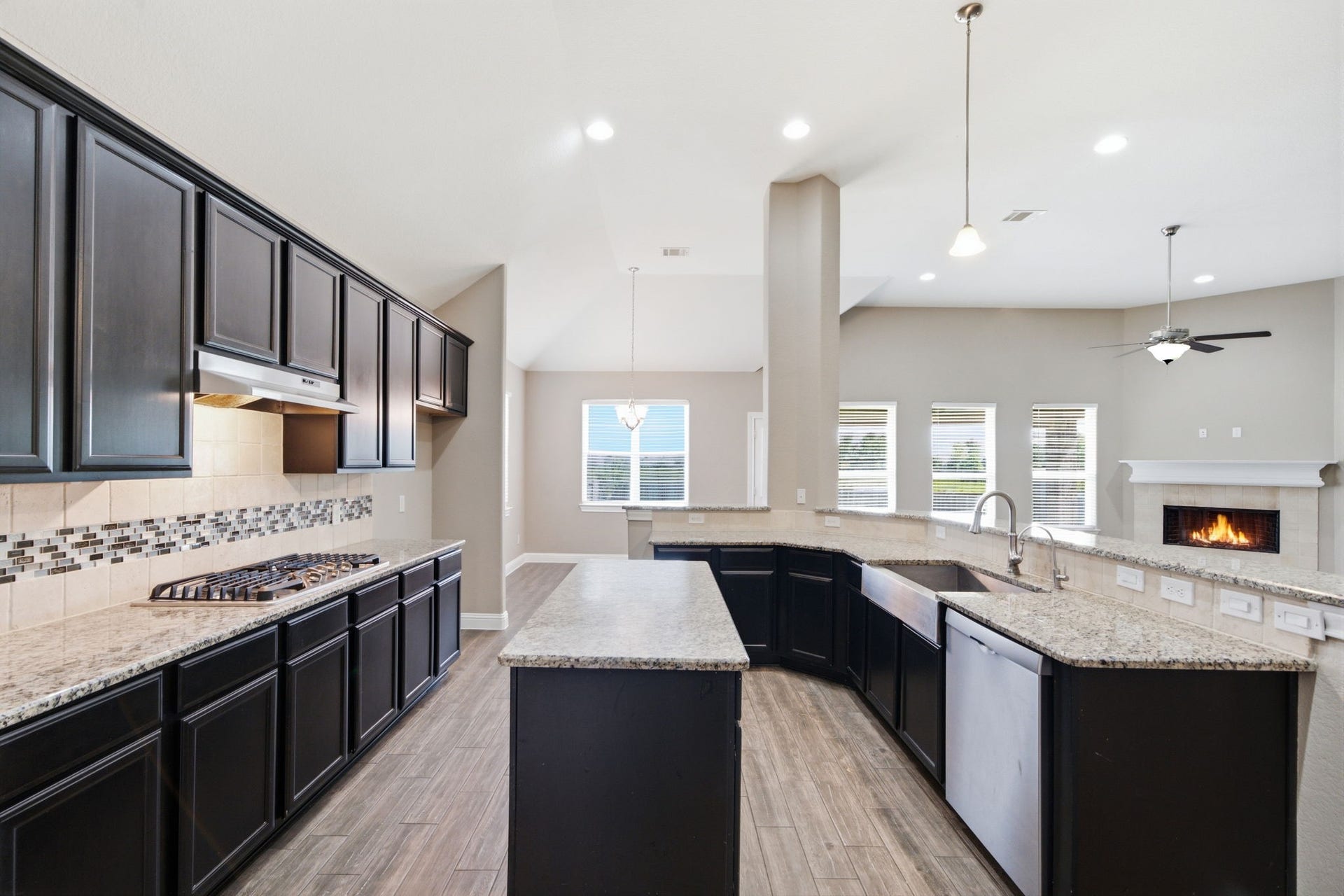 18818 Wichita Trail, Magnolia, TX 77355 Rich dark cabinetry, granite countertops, and stainless steel appliances anchor this expansive island kitchen. A breakfast bar overlooks the adjoining living room, keeping the chef connected to the homes open layout.