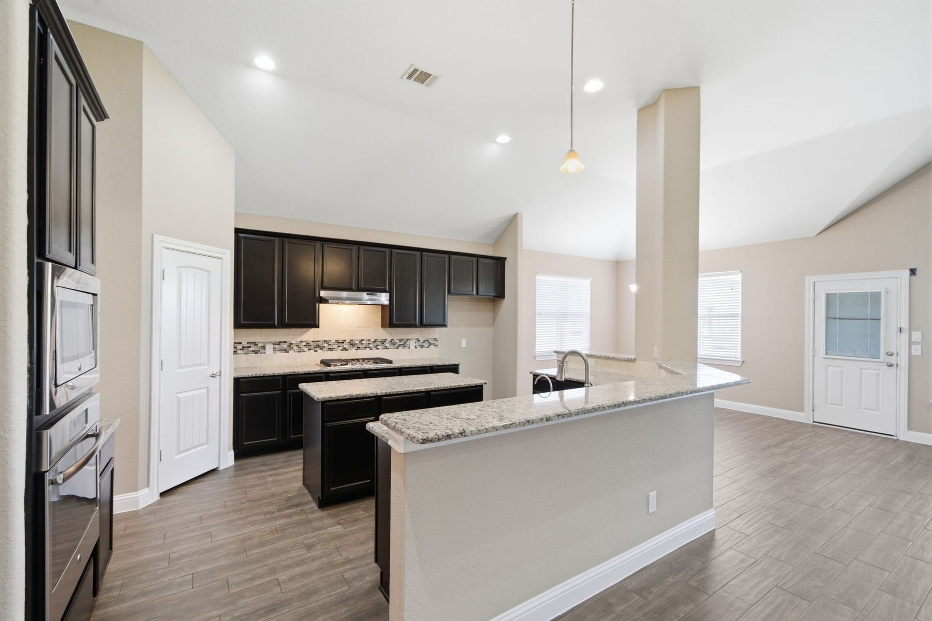 18818 Wichita Trail, Magnolia, TX 77355 Generous counter space and a raised breakfast bar make this kitchen as functional as it is inviting. The open-concept design flows seamlessly into the breakfast area and living room, with tile flooring uniting the spaces.
