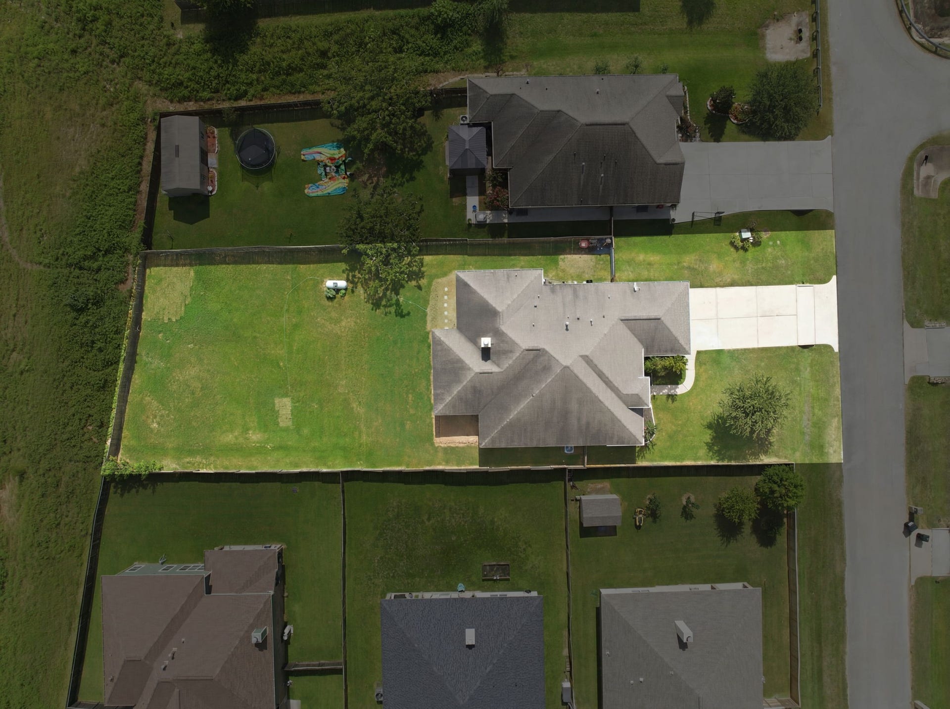 18818 Wichita Trail, Magnolia, TX 77355 Slightly elevated view captures this oversized lot showcasing the sprawling private fenced yard, double-wide driveway, and single-story home.